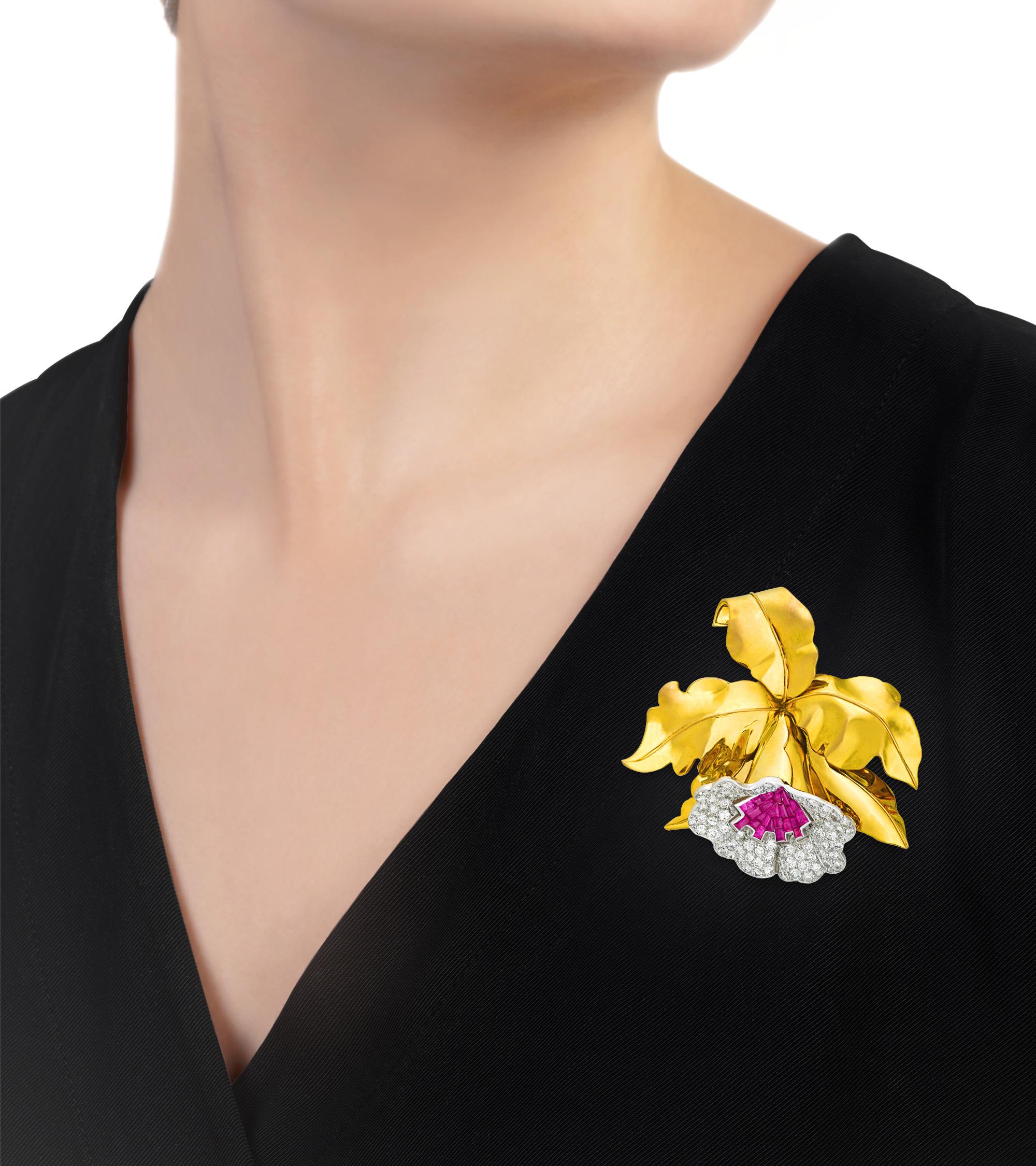 This sophisticated pin takes the form of a delicate French orchid. The floral brooch is accented by 85 diamonds totaling approximately 5.00 carats, and 22 rubies totaling approximately 3.00 carats. The glittering jewels shine in their 18K yellow