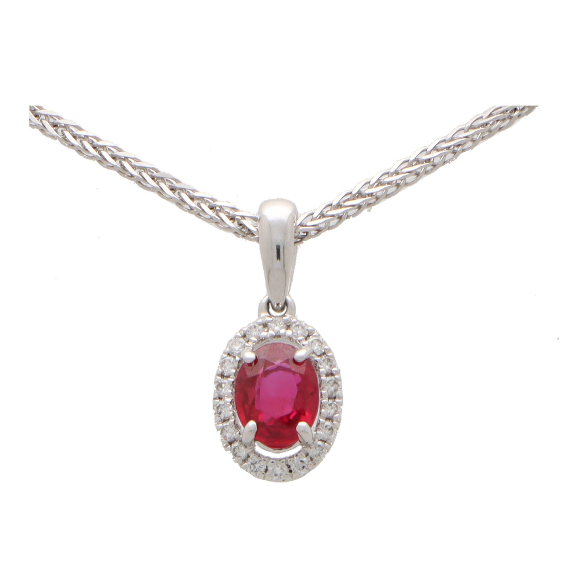  A beautiful oval cut ruby and diamond halo pendant set in 18k white gold.

The pendant is centrally set with a beautiful coloured red oval cut ruby which is surrounded by 18 sparkly round brilliant cut diamonds. The pendant hangs from a polished