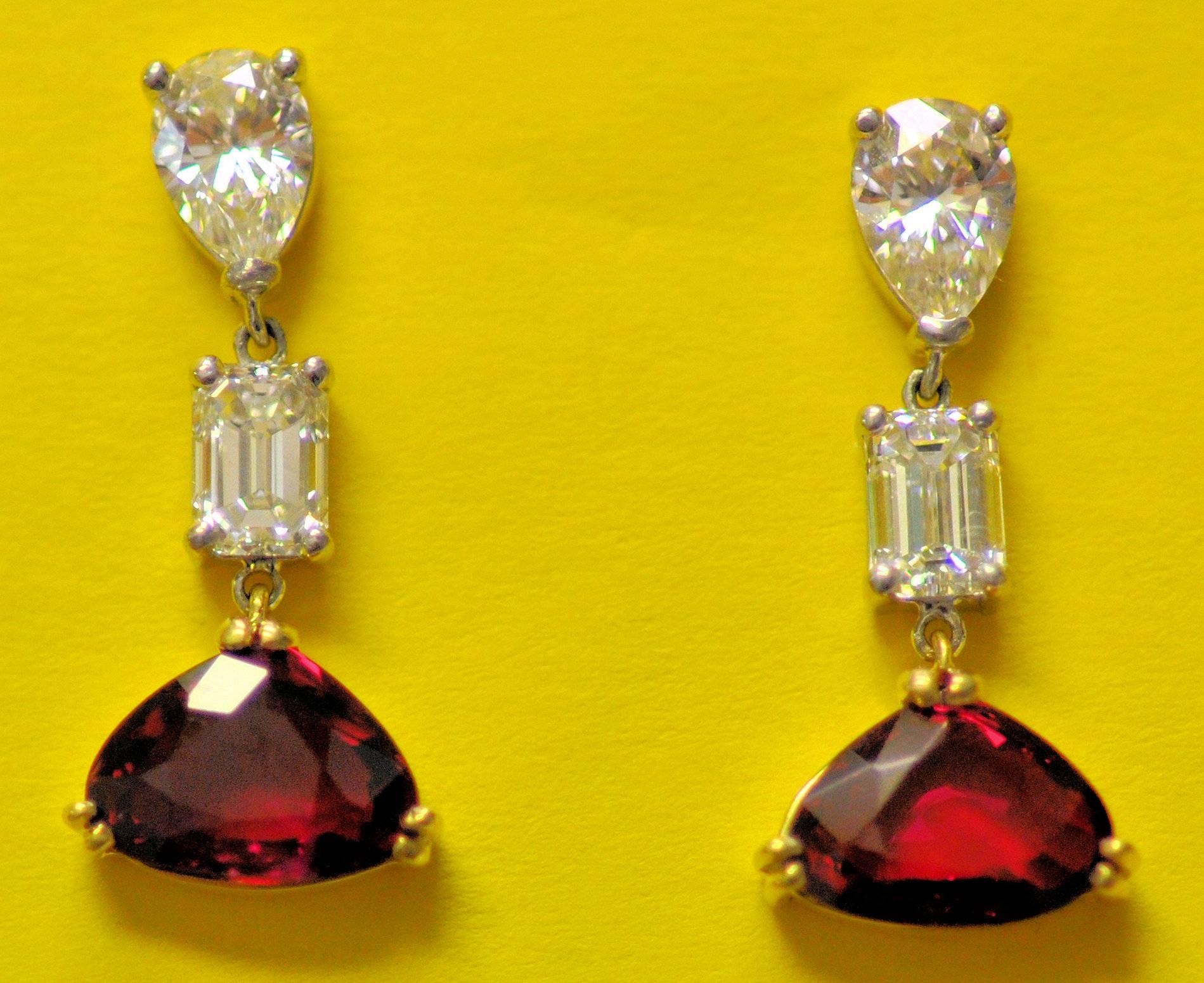 Pair of lovely, custom made platinum and 18 Karat yellow gold pendant earrings set with shield cut matching rubies together weighing 2.55 carats and two pear shape diamonds 0.80 carat total weight and two emerald cut diamonds weighing 0.88 carat