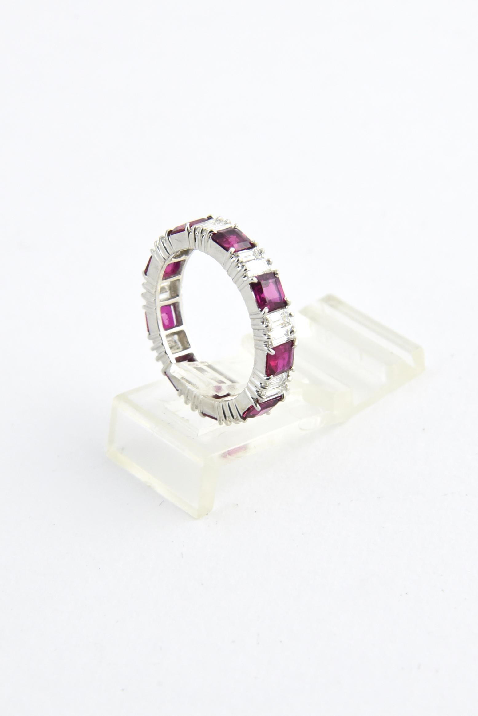 Platinum eternity band ring featuring nine square rubies with an approximate total weight of 5 carats and 18 baguette diamonds with an approximate total weight of 1 carat. No maker's mark. US size 6; cannot be sized.