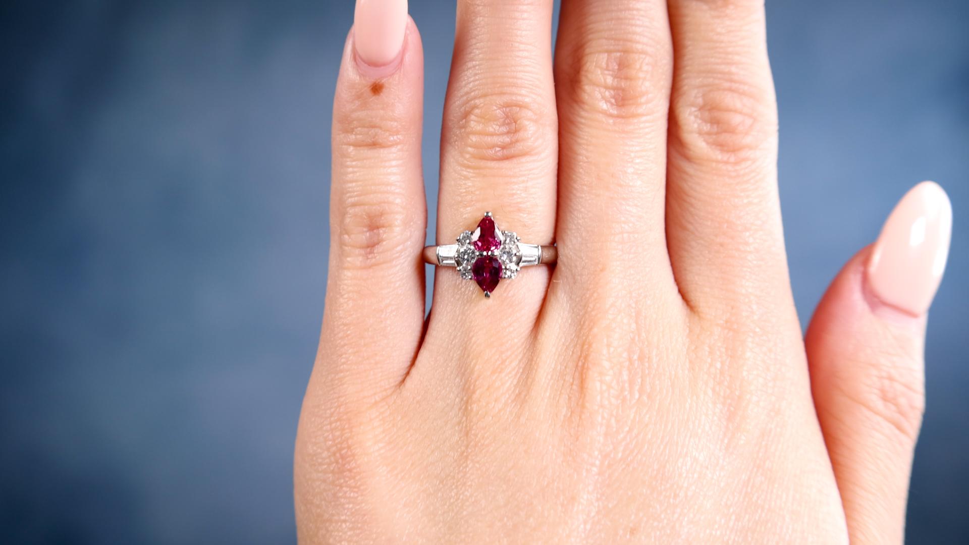 One Ruby and Diamond Platinum Ring. Featuring two pear cut rubies with a total weight of 0.80 carat. Accented by six round brilliant cut and four tapered cut diamonds with a total weight of 0.37 carat, graded colorless, VS-SI clarity. Crafted in