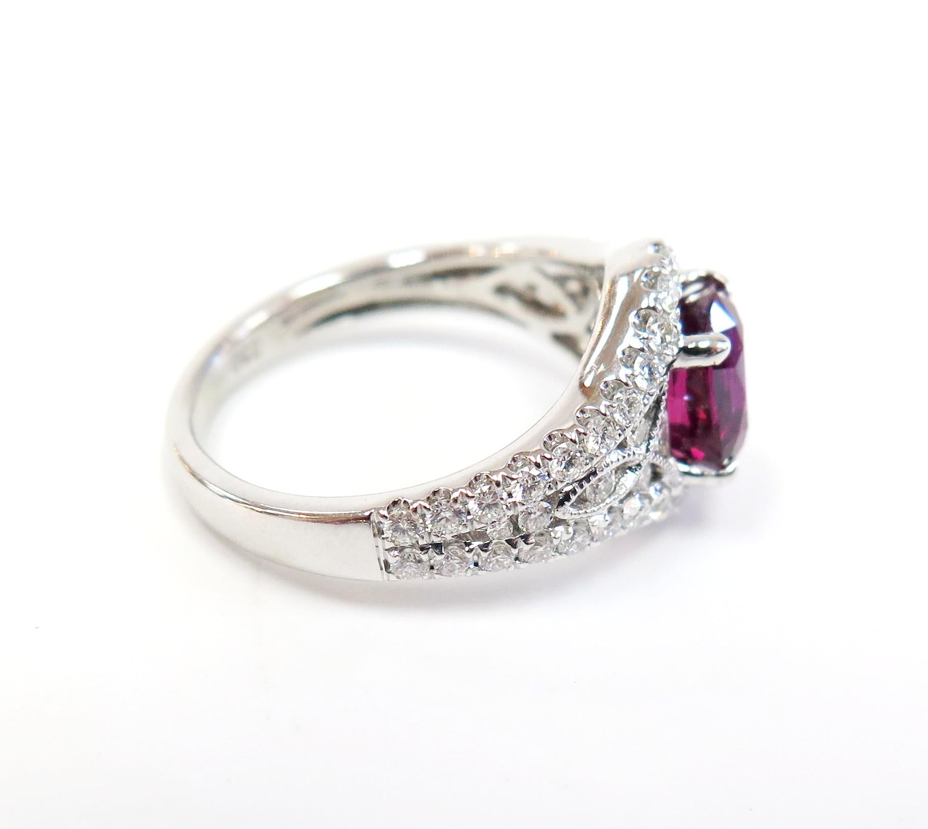 Rubies have often been seen as the gem of passion, love, and courage.
People born in July have this gem as their birthstone.
This vibrant oval ruby is surrounded by sparkling round brilliant diamonds in 18 karat white gold. 

Genuine Ruby: 1.05