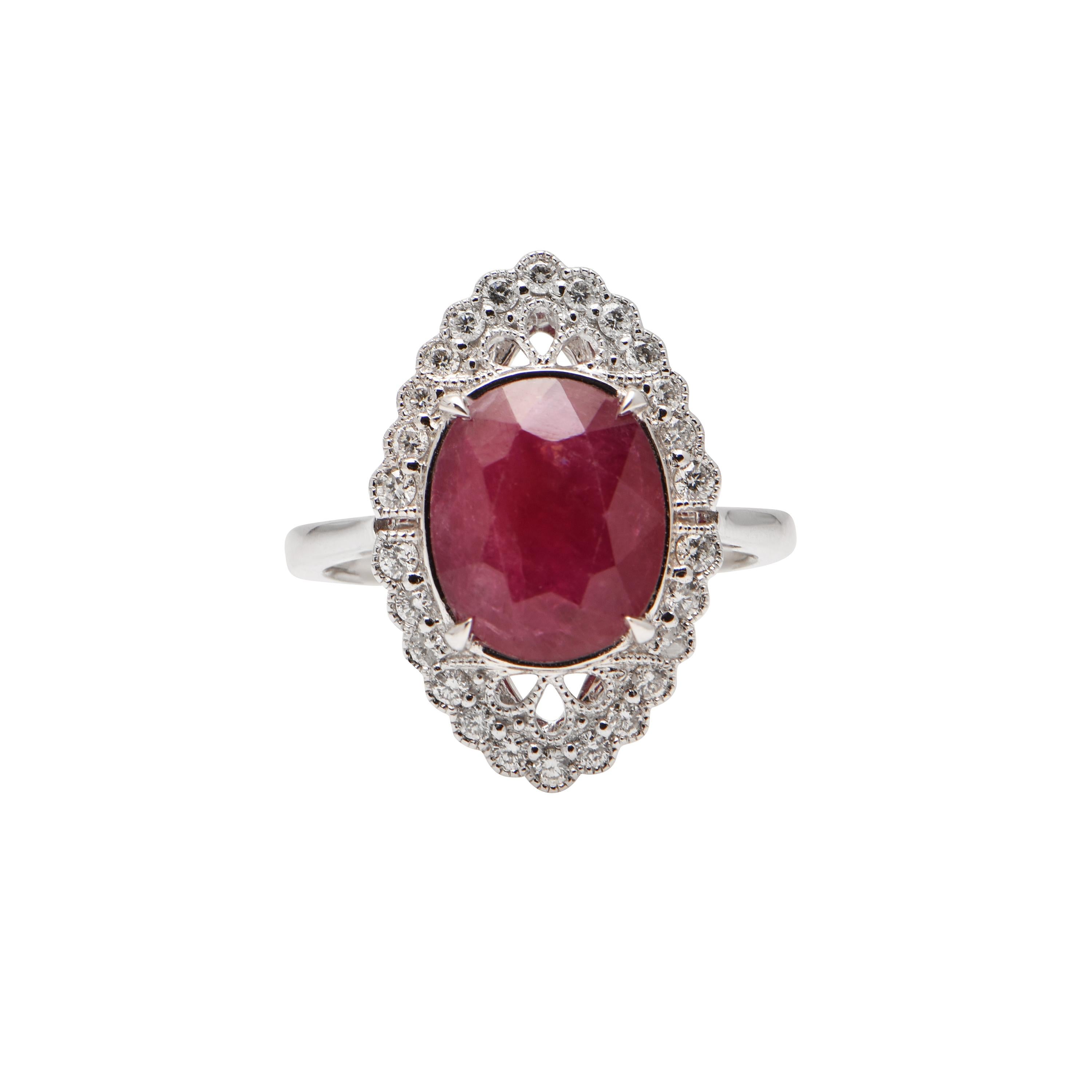 A Ruby (totalling 4.06ct), surrounded by 26 Diamonds (totalling 0.33ct), set in 18ct White Gold. Finger size L 1/2 (US 5 7/8).