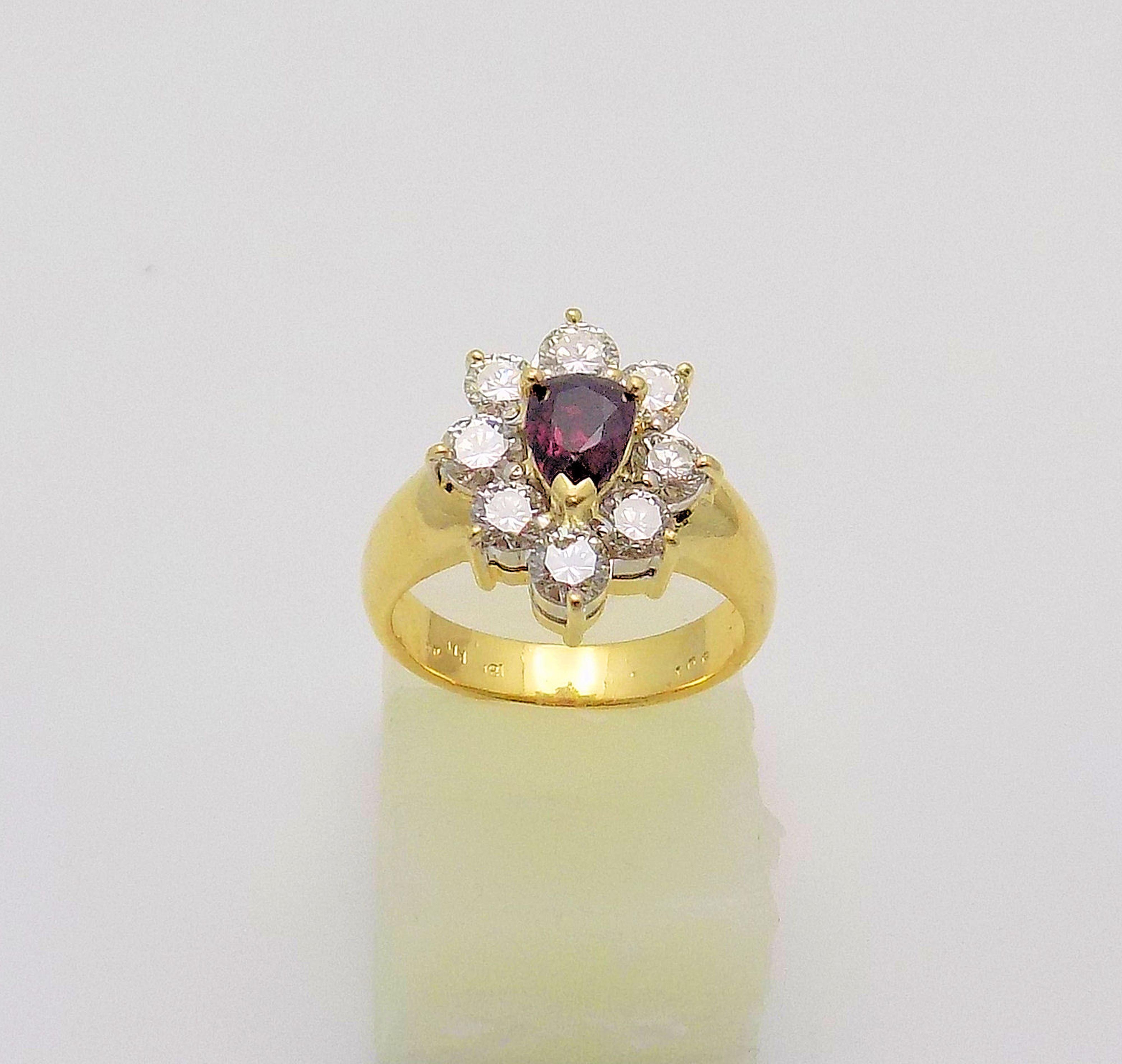 Classic 18 Karat Yellow Gold and White Gold Ring featuring 1 Pear Shape Ruby 1.00 Carat (Nick on Table), 8 Round Brilliant Diamonds 1.20 Carat Total Weight, VS, H-J; Finger Size 6; 5.1 DWT or 7.93 Grams.

The Jewelry Gallery offers ring sizing (at