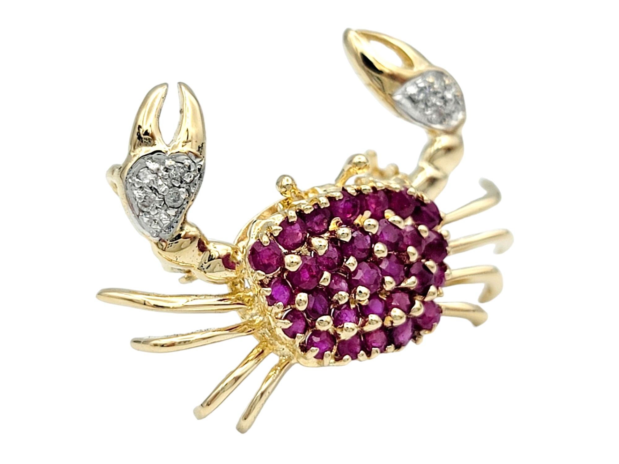This beautiful crab brooch or pendant, set in lustrous 14 karat yellow gold, is a captivating and unique piece of jewelry. The body of the crab is adorned with vibrant red rubies, creating a striking and eye-catching display. The use of rubies for
