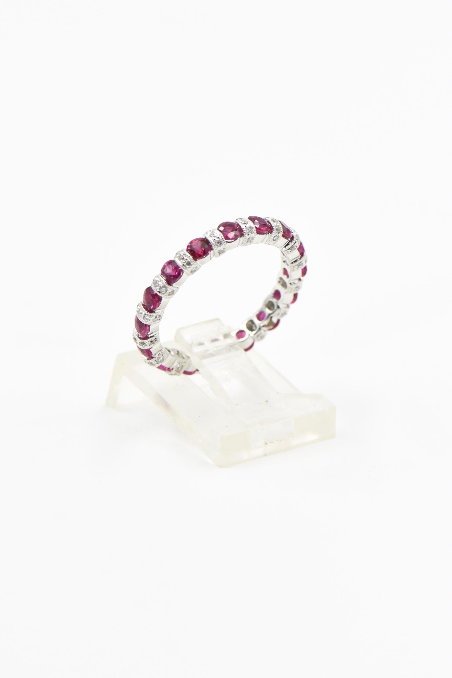 Beautifully made ruby eternity band with diamond spacer bars set between the rubies.  Each spacer bar has 5 small diamonds.
The band is 2.73 mm wide at the rubies and 2.97 mm at the diamond bars.  The band is made of 18k white gold.
US size 6.5 