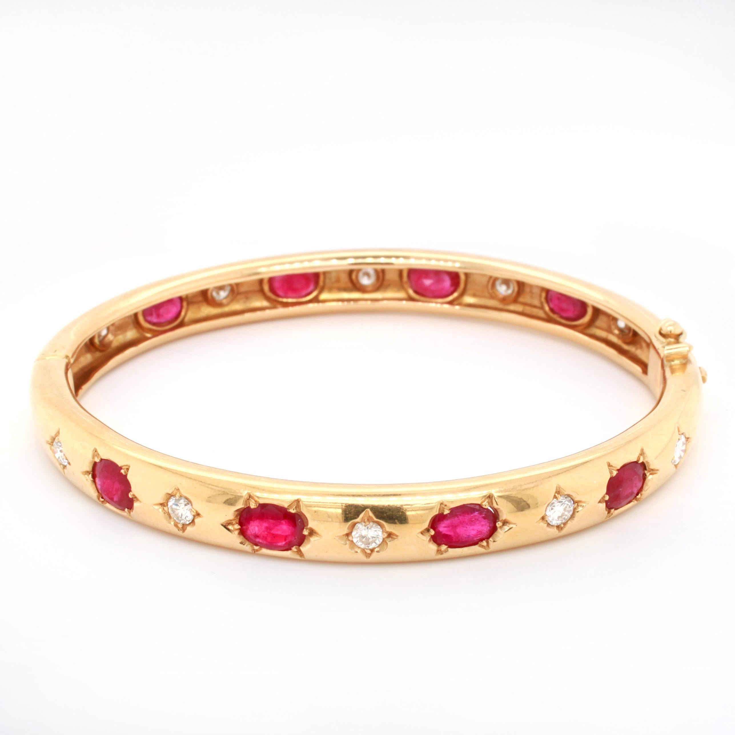 A ruby and diamond bangle in 18k yellow gold. The bangle is alternatingly set with eight cushion shaped rubies, probably of Burmese origin, weighing approximately 6 carats in total and ten round brilliant cut diamonds, weighing approximately 1.2