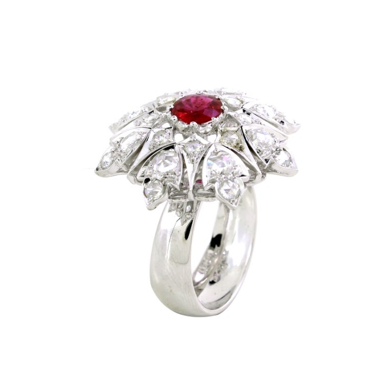 A timeless tribute to vintage elegance, this exquisite ring features a rich, fiery ruby at its heart, weighing 0.83cts., symbolizing passion and strength. Surrounding the center stone, delicate petals adorned with shimmering rose-cut diamonds, with