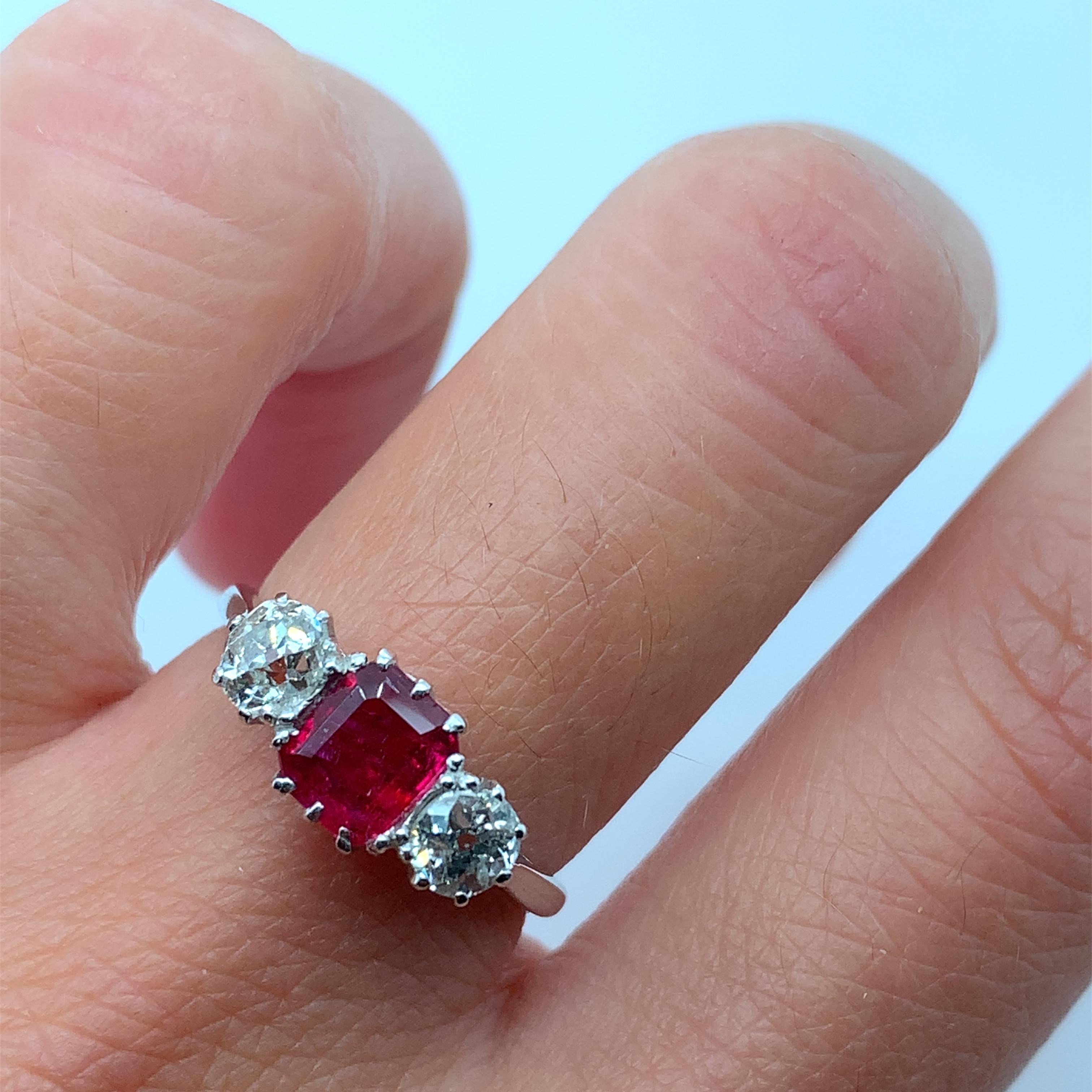 This stunning engagement ring from Trilogy features a beautiful 1.54ct ruby, set in platinum. The ring is adorned with three stones ruby and old cut diamonds, two of which are round European old cut diamonds , giving it a unique and elegant look.