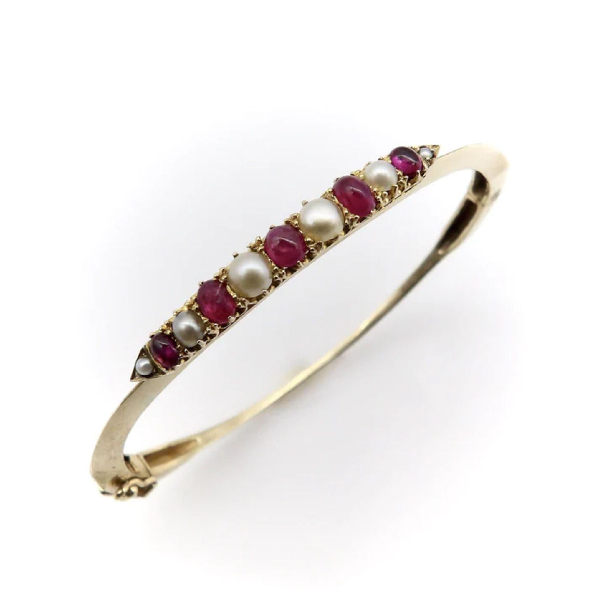 The centerpiece of this charming bracelet was most likely once a brooch, converted at some point into a stylish bangle. It contains six round half pearls and five oval-shaped cabochon rubies, prong-set into an alternating pattern, that has been
