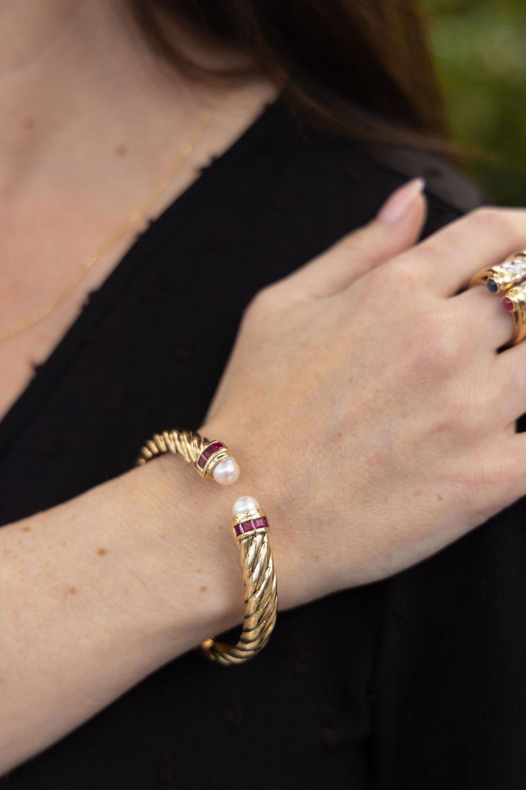 Bracelet à charnière ouverte en or jaune 18 carats comprenant 2 perles de culture mesurant 7,5 mm et 10 rubis de taille carrée totalisant environ 2,00 carats. Le poids fini est de 40,6 grammes.