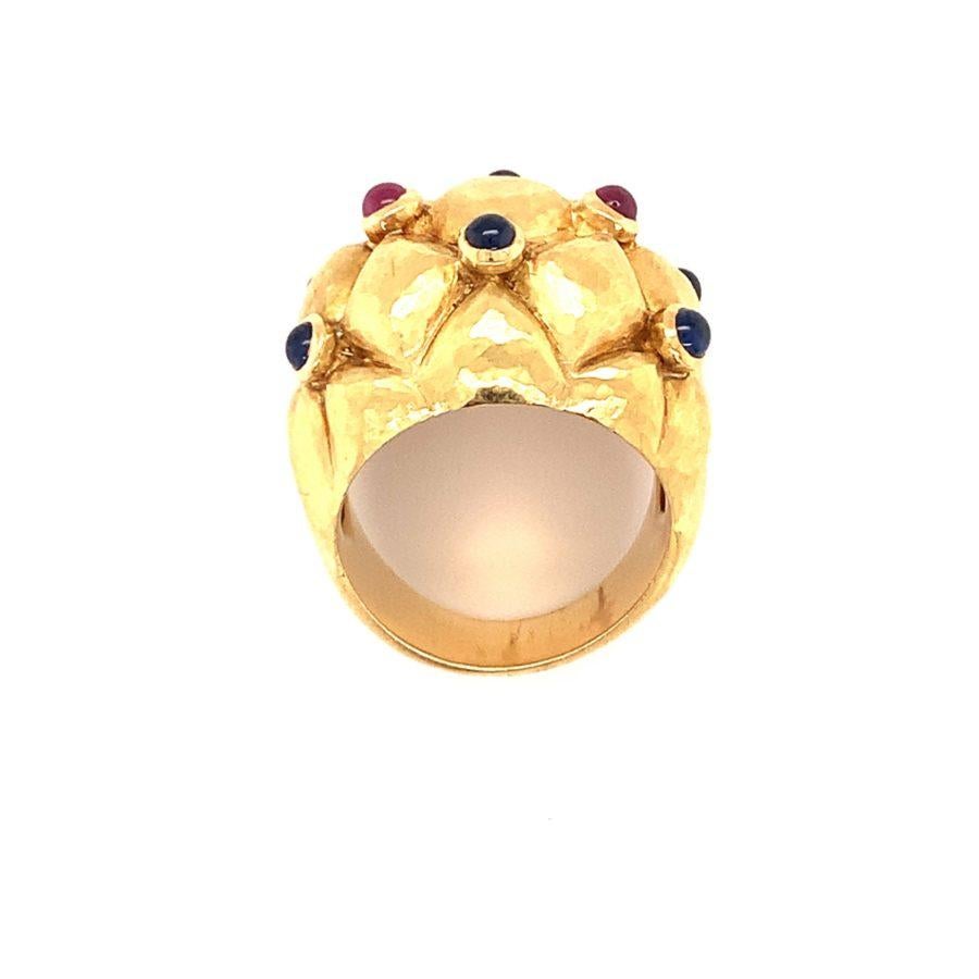 One ruby and sapphire 18K yellow gold ring featuring two round cabochon rubies totaling 0.25 ct. and six cabochon sapphires totaling 0.75 ct. The ring features hammered gold work as well as a puffed gold design. Italian hallmarks.

Fancy,