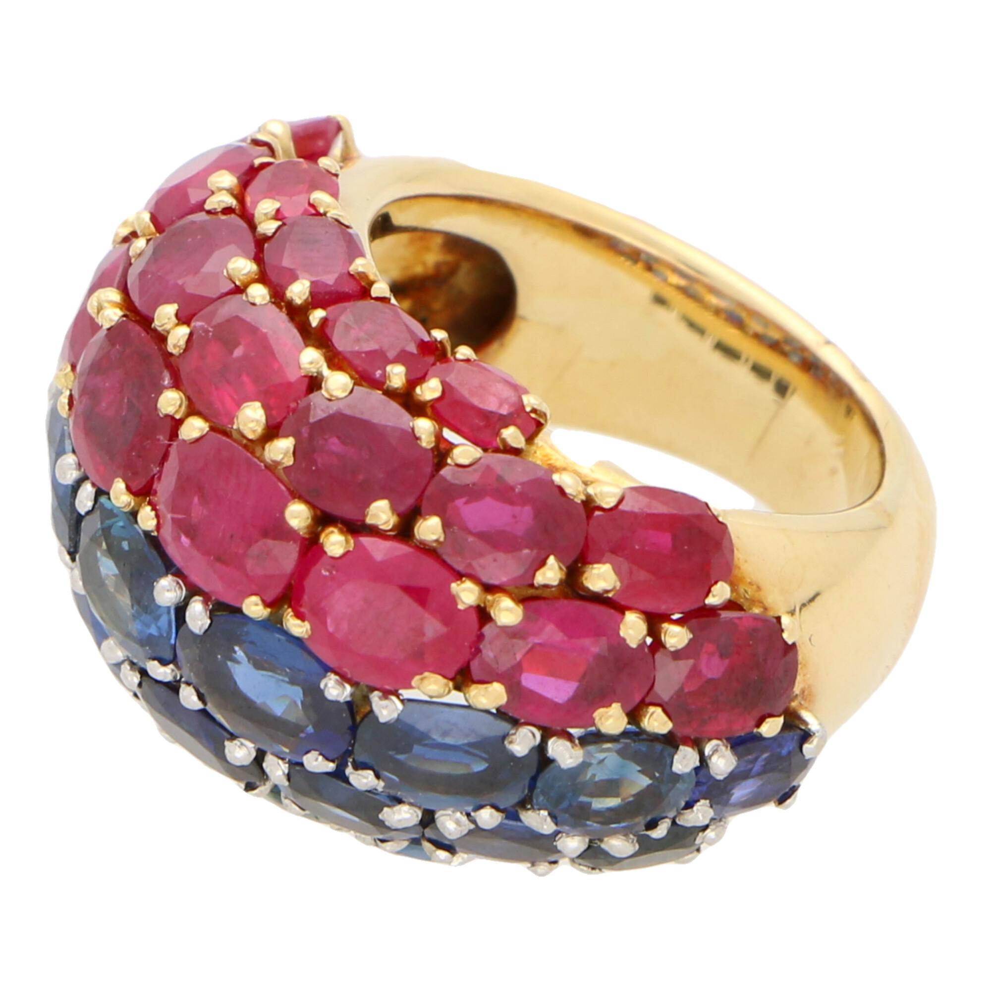 A highly unique ruby and sapphire bombe dress ring set in 18k yellow gold and platinum. 

The ring is firstly composed of 22 oval cut royal blue sapphires, all of which graduate ever-so slightly in size as the design travels across the finger. These