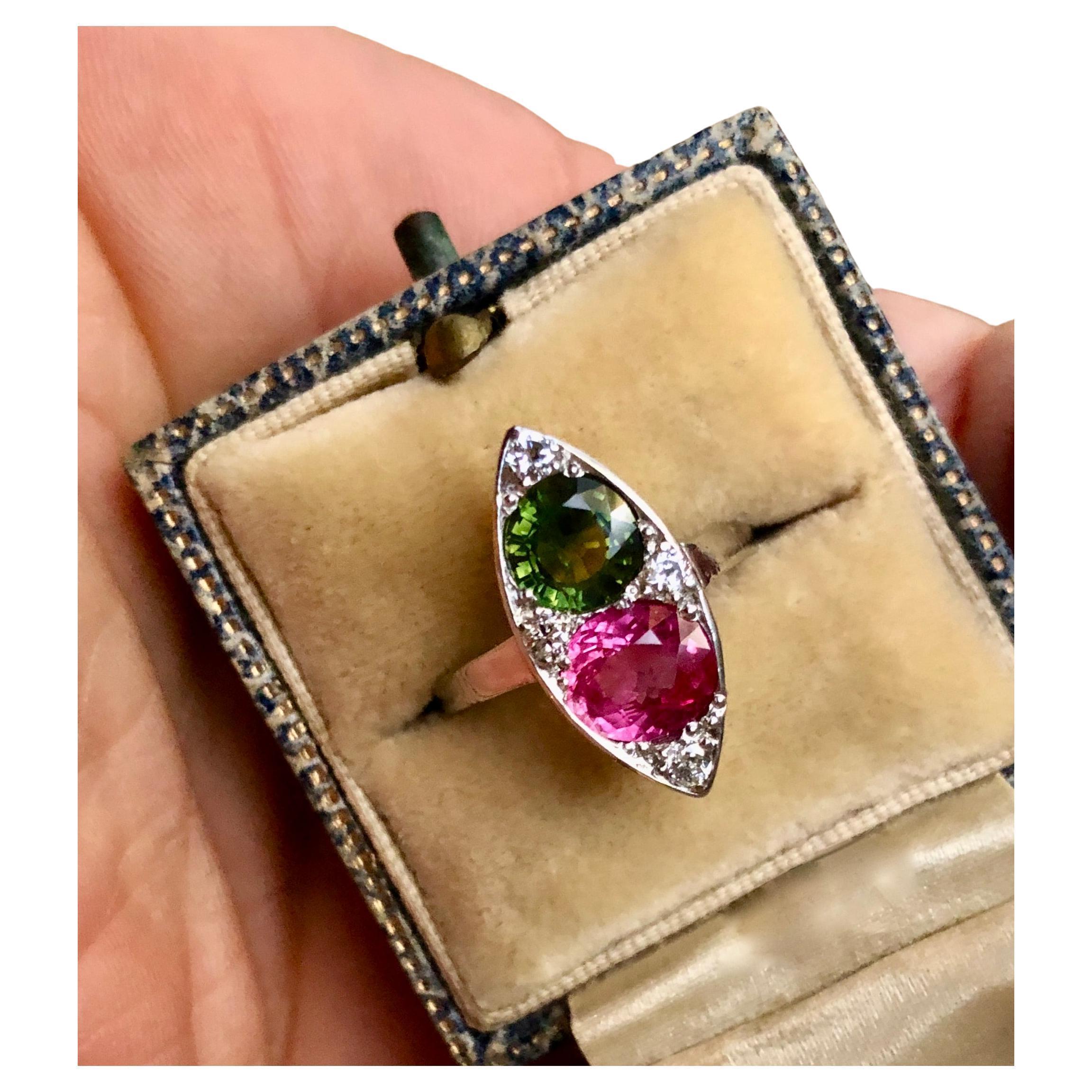 An Antique  Art Deco Style natural Ruby and Sapphire Platinum Navette Ring.  The ring is accented with one, round old cut pinkish red untreated natural ruby, one round cut green natural sapphire, and four, bead set, round single cut white diamonds.