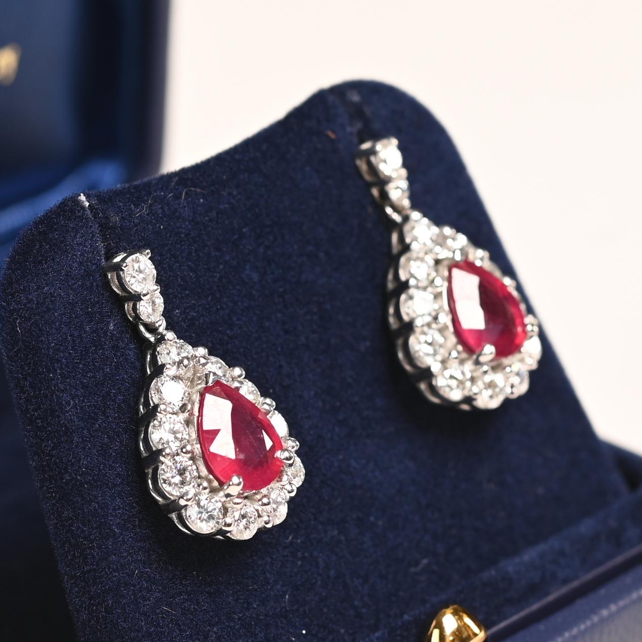 Questo squisito paio di orecchini con rubini e diamanti è una testimonianza di eleganza e maestria senza tempo. Al centro di ogni orecchino si trova un affascinante rubino Burma a forma di pera, con un peso complessivo di circa 3,42 carati. Questi