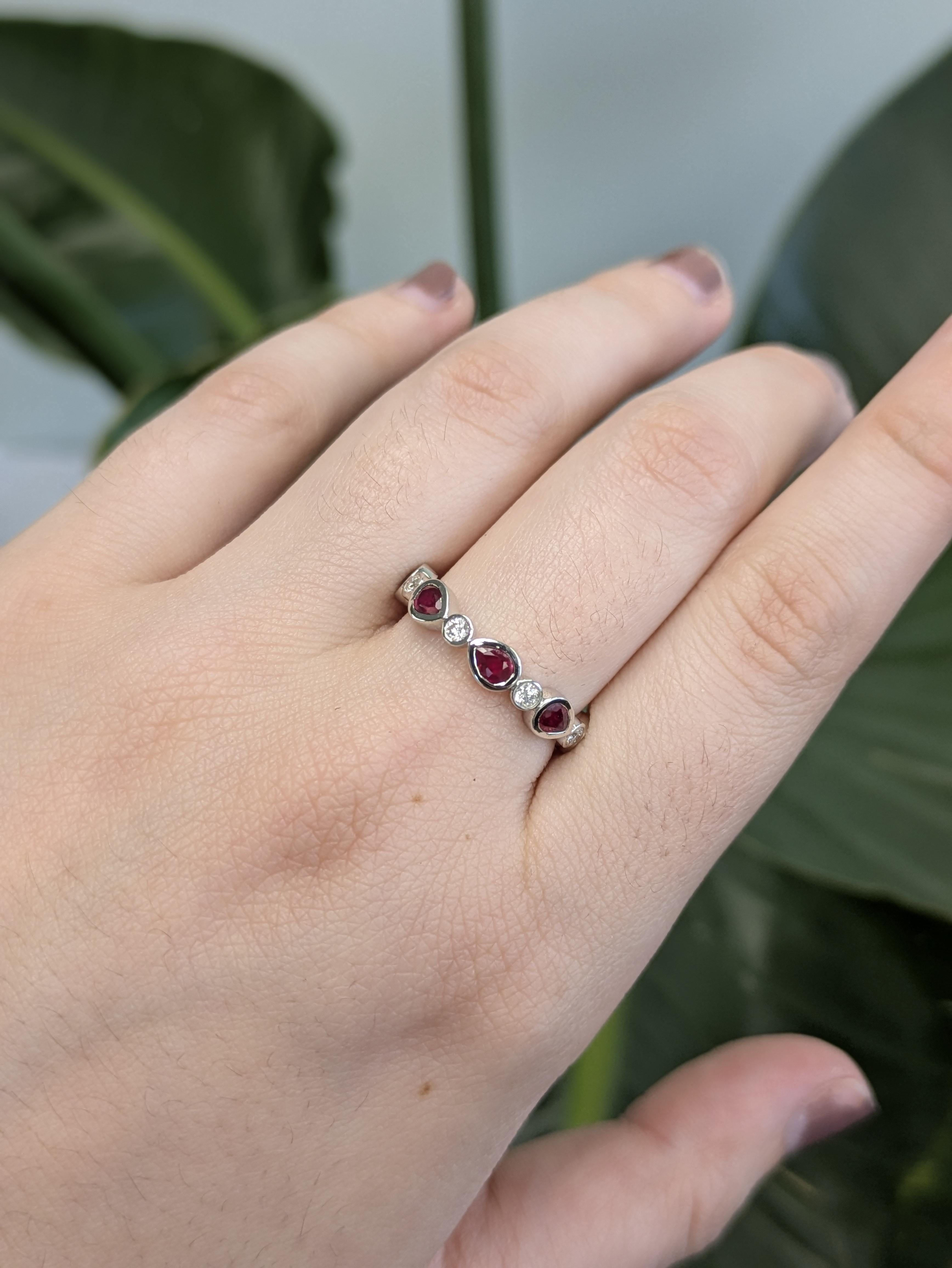 Celebrate love with a twist—this exquisite band features six glowing pear-shaped rubies, each bezel-set to showcase their regal shape and brilliance. Nestled between the rubies are twinkling round natural diamonds, adding a touch of shimmer to every
