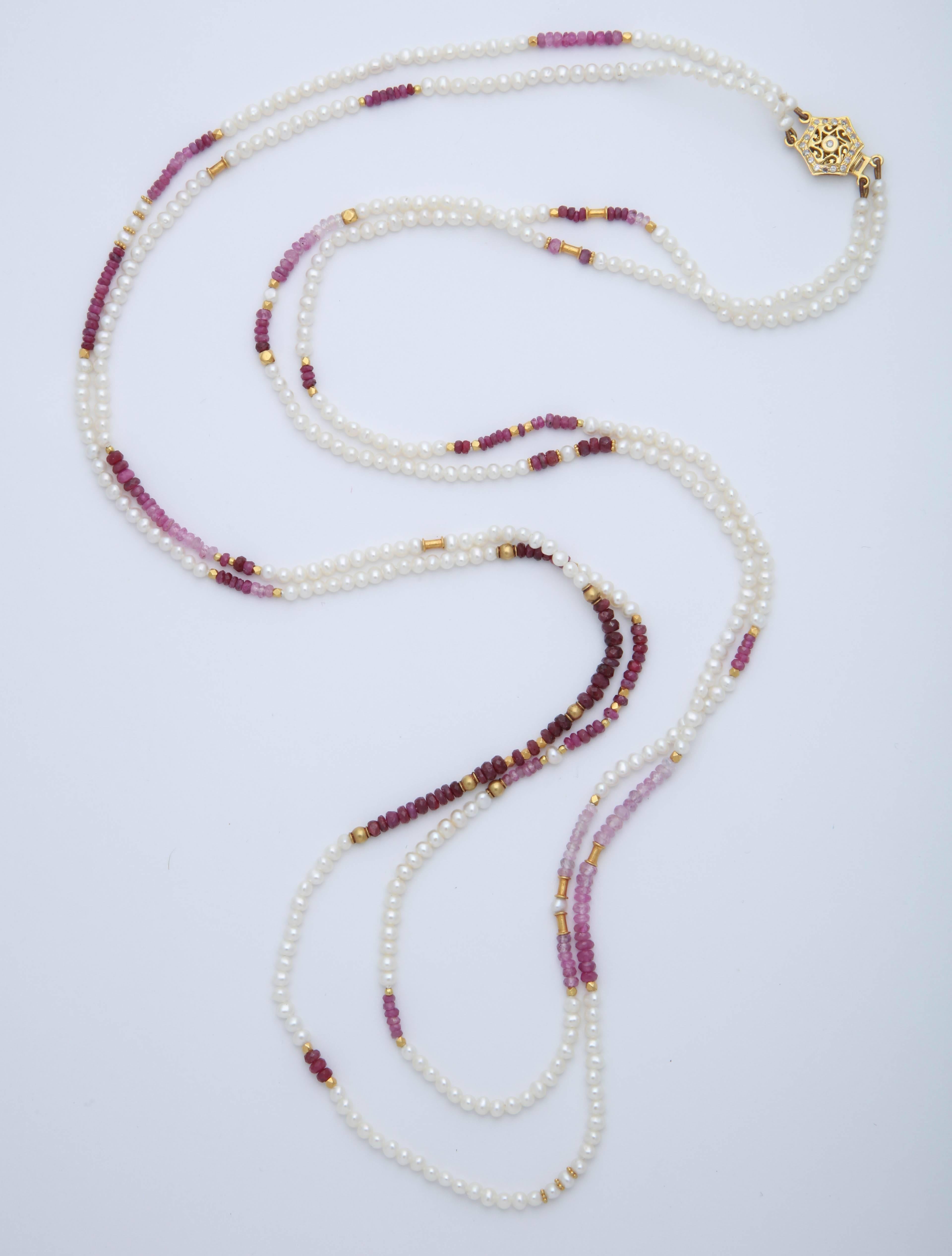 This is a double strand of natural ruby beads, 18 kt gold beads and white fresh water pearls. It is 31 in. long and closes with an 18 kt gold and diamond clasp. This can be wrapped twice around the neck or also  wrapped as a bracelet.