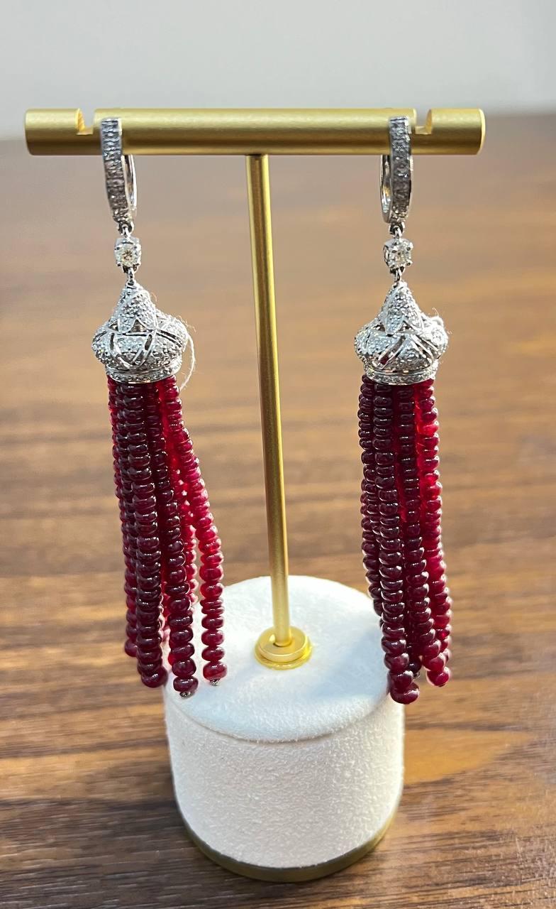 These striking earrings are crafted in 18k white gold.

Each earring features a round, white diamond with VS1 clarity and F color grade, set in a delicate white gold setting, 1.9 TCW.

Suspended from the diamond is an intricate cap adorned with