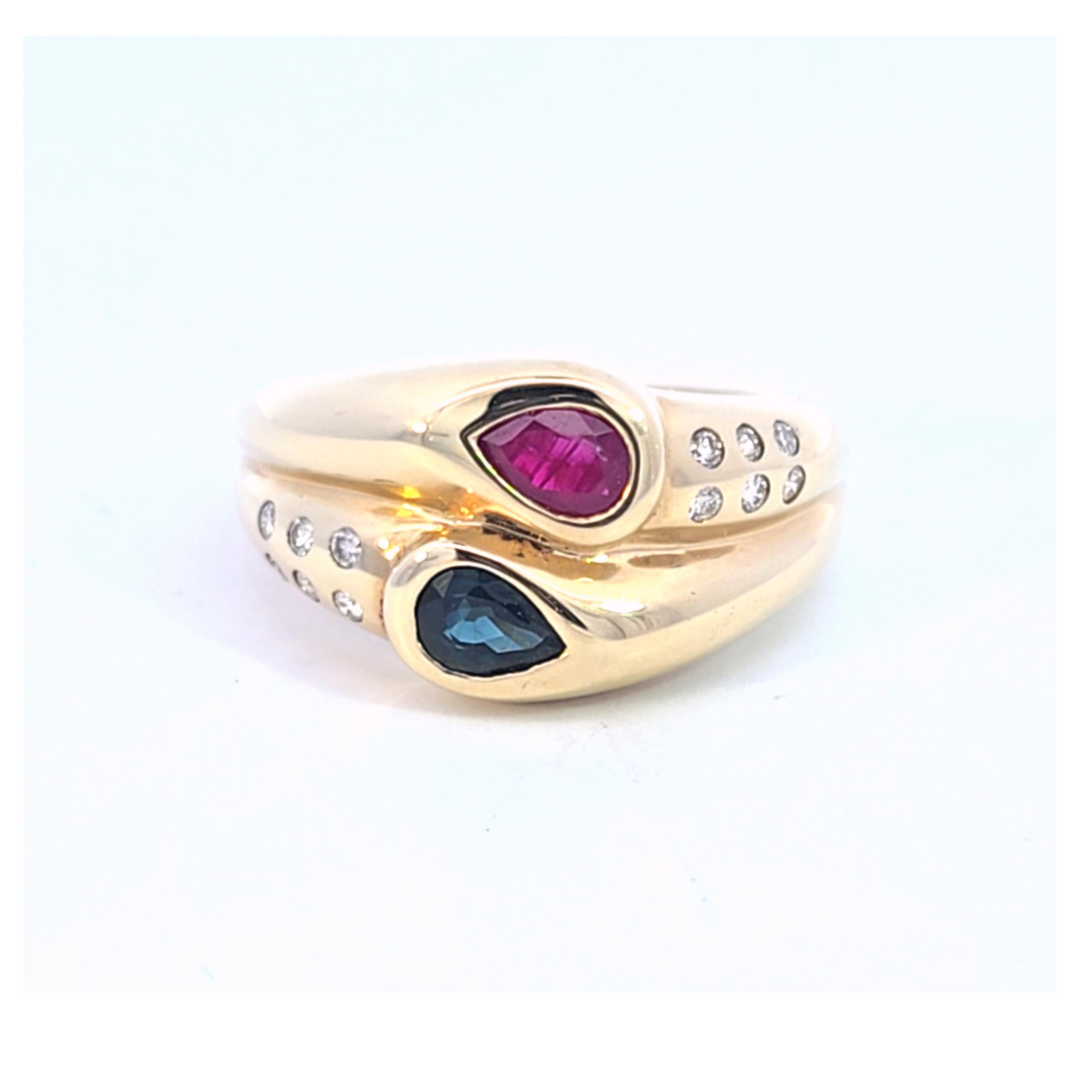 Diese Schönheit besteht aus einer hochglanzpolierten Fassung aus 14 Karat Gelbgold und trägt einen birnenförmigen Rubin und einen birnenförmigen blauen Saphir in Lünettenfassung, die mit Diamanten besetzt sind. 