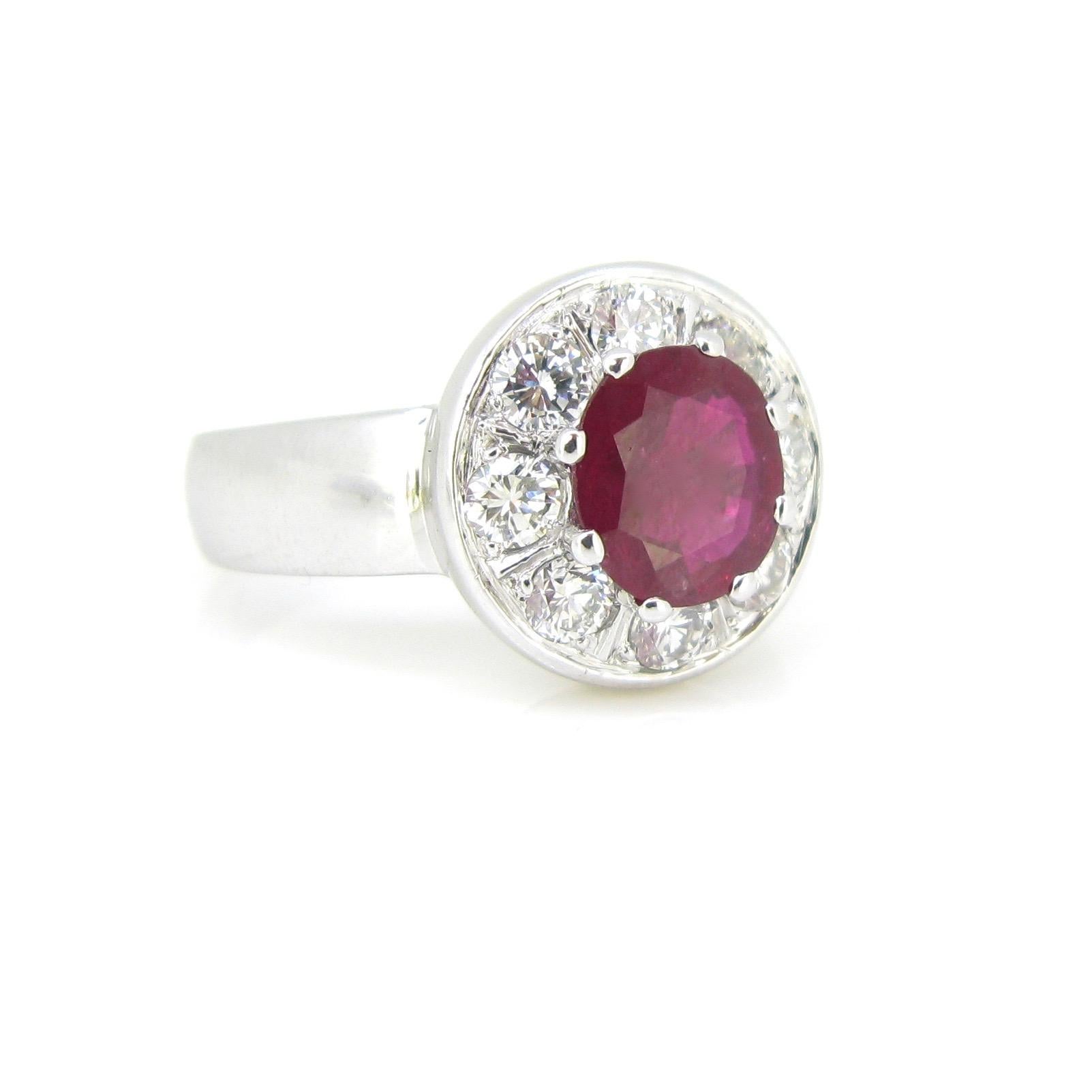 This ring is set with a natural Thaï Ruby weighing 1,83ct. It is surrounded with 8 brilliant cut diamonds. There is an approximate total carat weight of 1,20ct. The diamonds have a good color (H) and a good clarity (VS). The mount is bold and shiny.