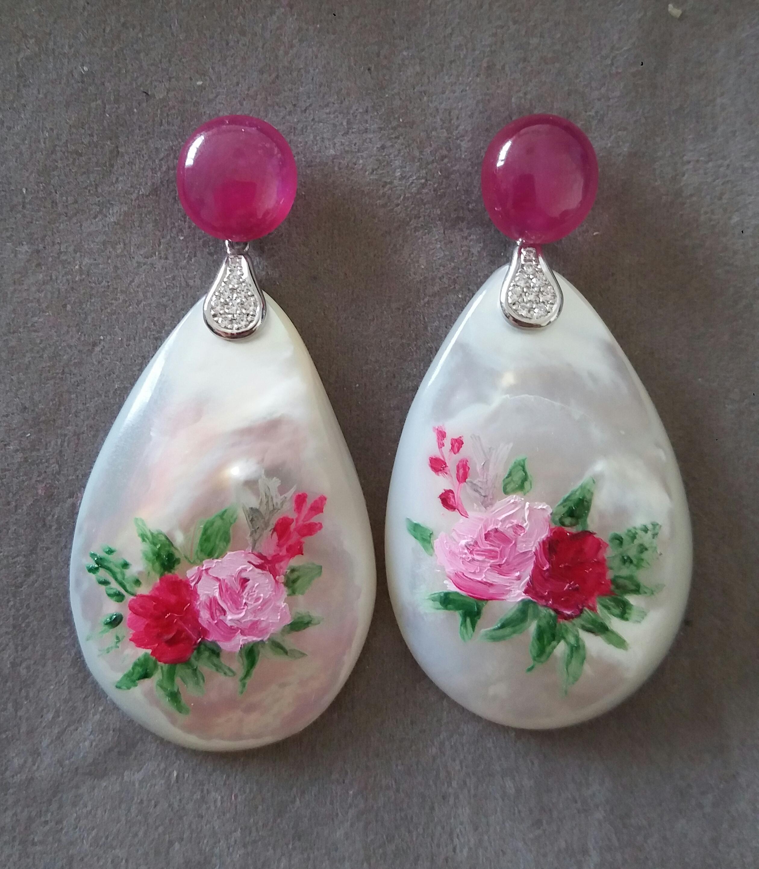 Vintage pair of hand painted pear shape Mother of Pearls  measuring 28x44 mm depicting 1 red rose and 1 pink rose with green foliage ,suspended from 2 Ruby Oval cabs measuring  11x12 mm  by 2 elements in 14 K white gold and 16 small round brilliant
