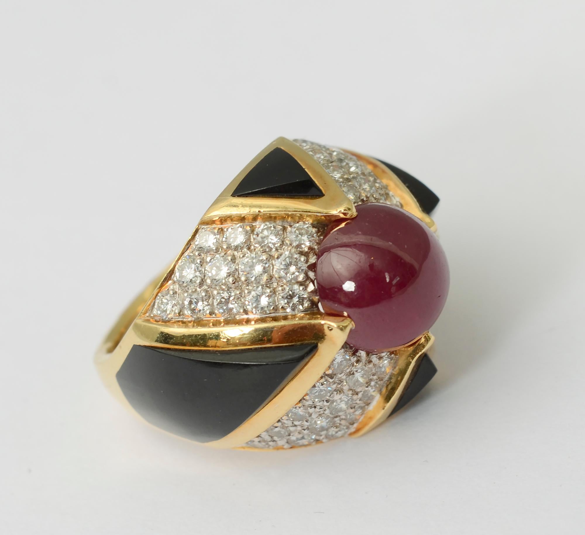 Custom made, elegant domed cocktail ring of ruby; diamonds and carved black onyx. The central cabochon ruby is approximately 4 carats. Geometric shapes of carved onyx overlap the ruby to serve as prongs. The ring is size 
6 1/2 with an interior