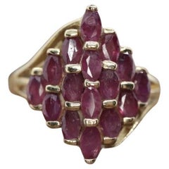 Anillo de oro de 10 quilates con racimo de rubíes. Forma de cúpula marquesa.