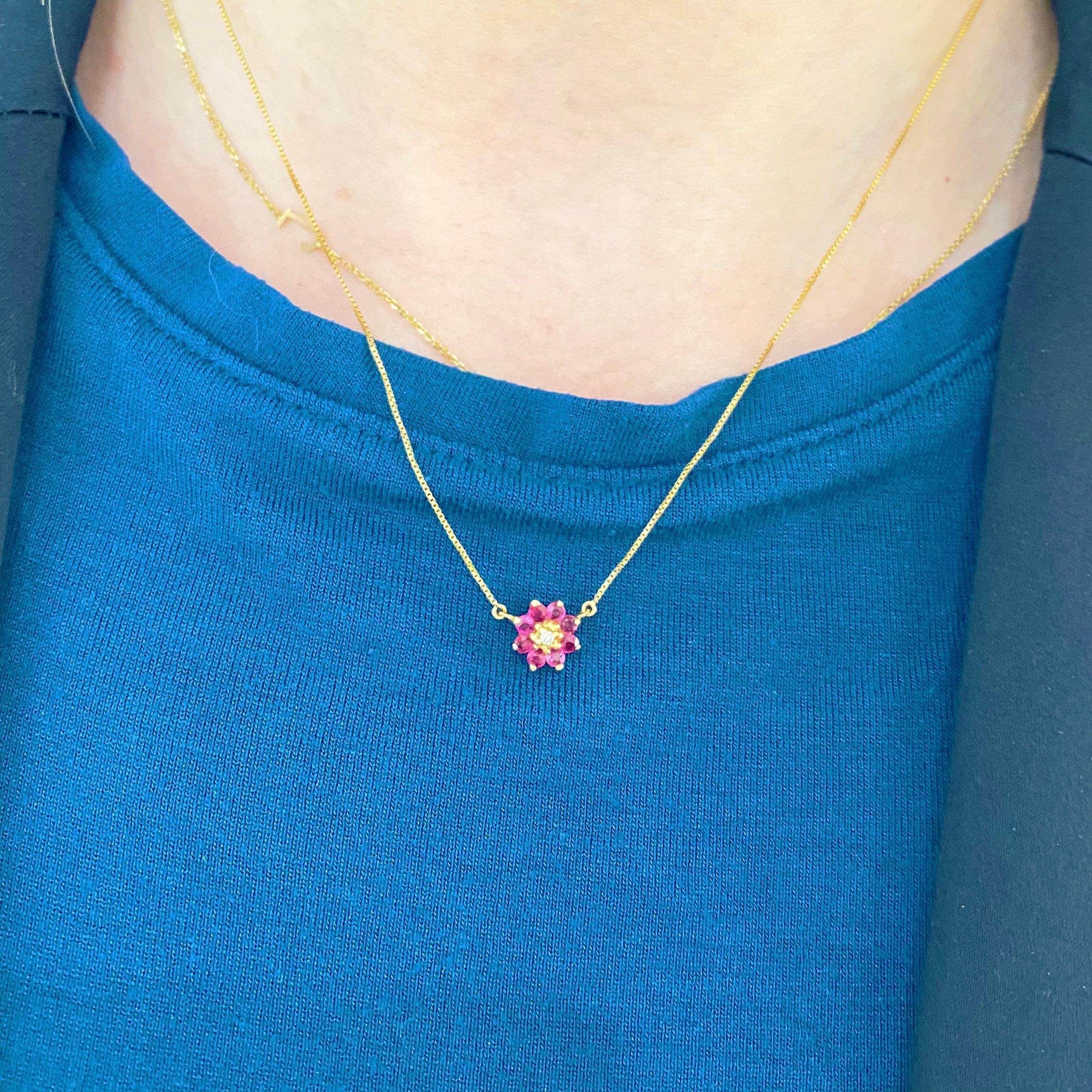 Gorgeous nine stone ruby and diamond flower pendant and chain! The necklace has 8 beautiful rubies encircling a round brilliant diamond, set in a gorgeous floral arrangement! The necklace goes with everything! Wear it on its own as a statement,