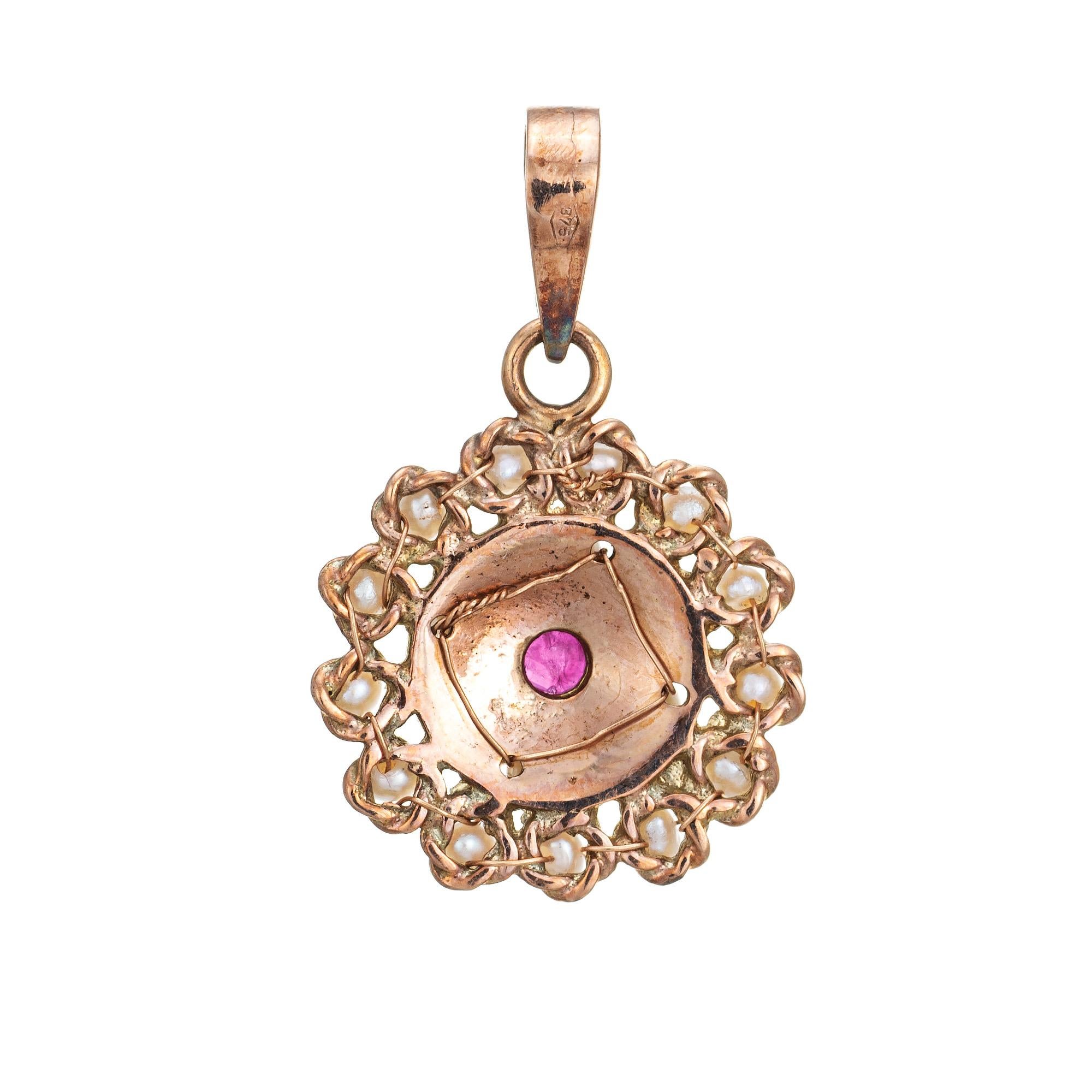 Finely detailed vintage ruby & cultured pearl pendant crafted in 14k yellow gold (circa 1950s to 1960s).  

Center set ruby measures 2.5mm, accented with cultured & natural pearls measuring 1.5mm to 2mm.

The nicely detailed pendant is small in
