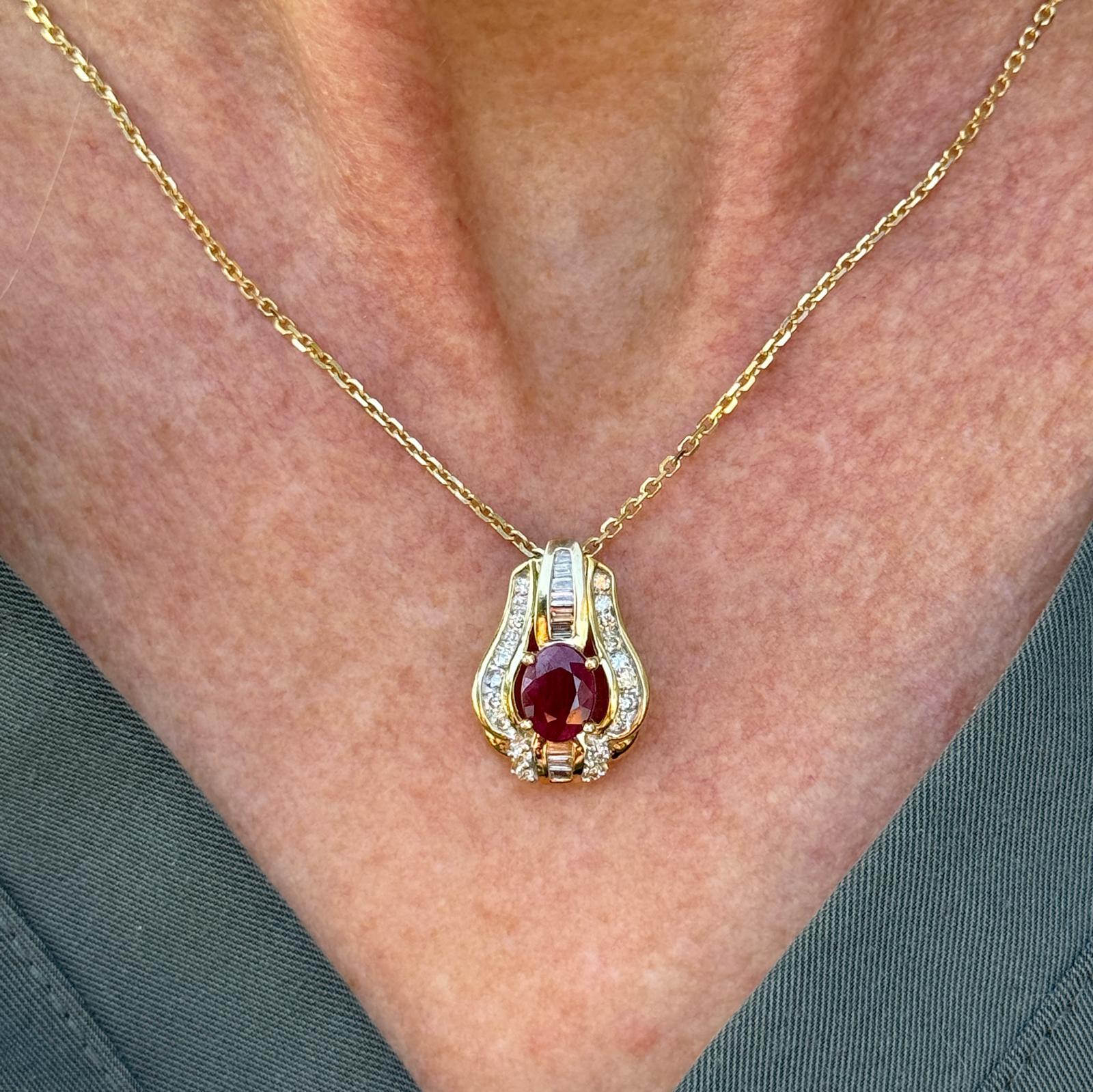 Le point focal du pendentif est un rubis ovale vibrant (environ 1,35 carat), connu pour sa teinte rouge profond symbolisant la passion et la vitalité. Autour du rubis, 20 diamants ronds de taille brillant et baguette étincellent, ajoutant de l'éclat