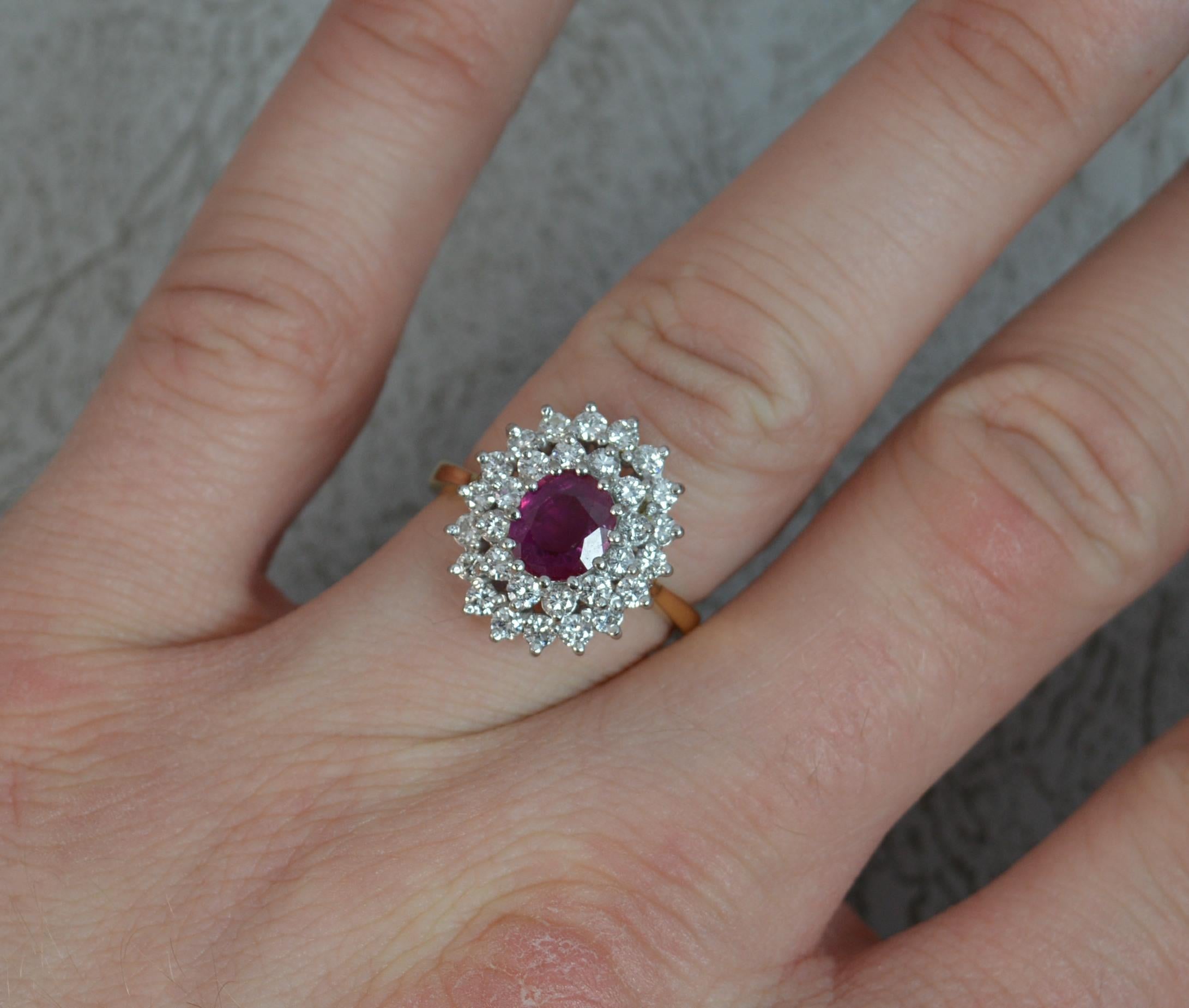A superb Ruby and Diamond cluster ring in 18ct Gold.
Designed with an oval cut ruby to centre, vivid pink red colour. Surrounding are two rows of round brilliant cut diamonds to total over 0.75cts.
14.2mm x 16mm cluster head, protruding 8.5mm off