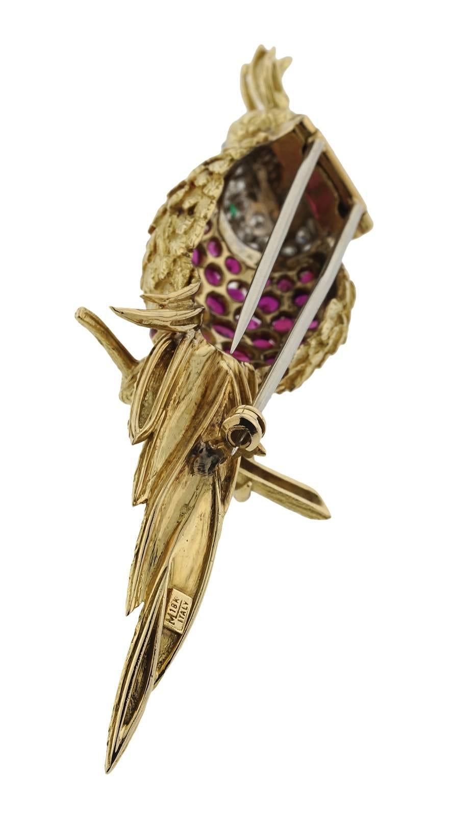 Beautiful Bird Motif pin in 18k yellow gold. Pin weighs 16.00 dwt and contains 38 round rubies weighing approx 6.00ct, 39 round diamonds weighing 1.50ct with G/H Color VS/SI clarity, and one round emerald weighing .15ct. stamped with a makers 