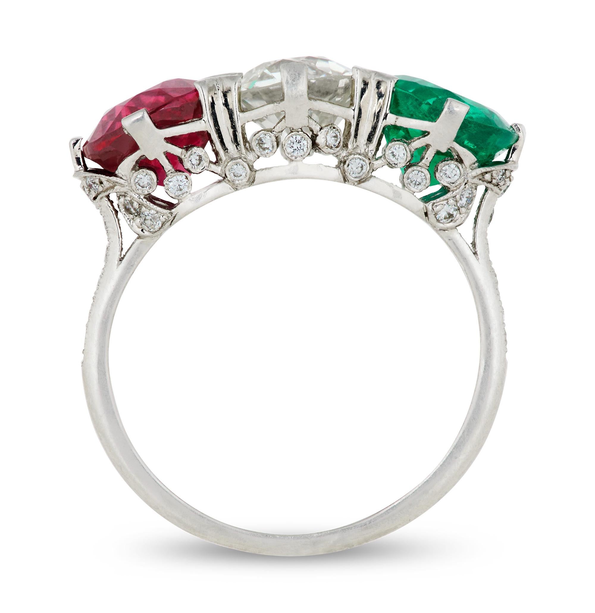 Questo squisito anello a tre pietre presenta un vibrante Trio di gemme rotonde: un rubino infuocato di 1,87 carati, un diamante di taglio europeo antico di 1,61 carati e un ricco smeraldo di 1,42 carati. Il design d'epoca è un raro e accattivante