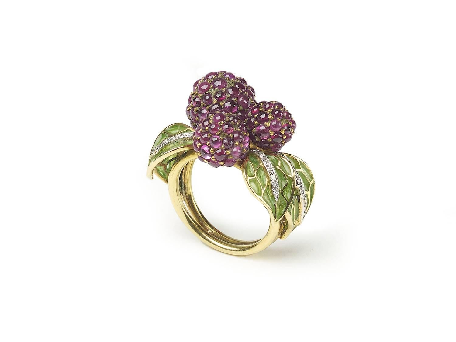 A ruby, enamel and diamond raspberry ring, with three central raspberries, pavé set with cabochon-cut rubies, with green plique à jour enamel leaves, with diamond detail, mounted in yellow gold.

Finger size UK M / US 6.