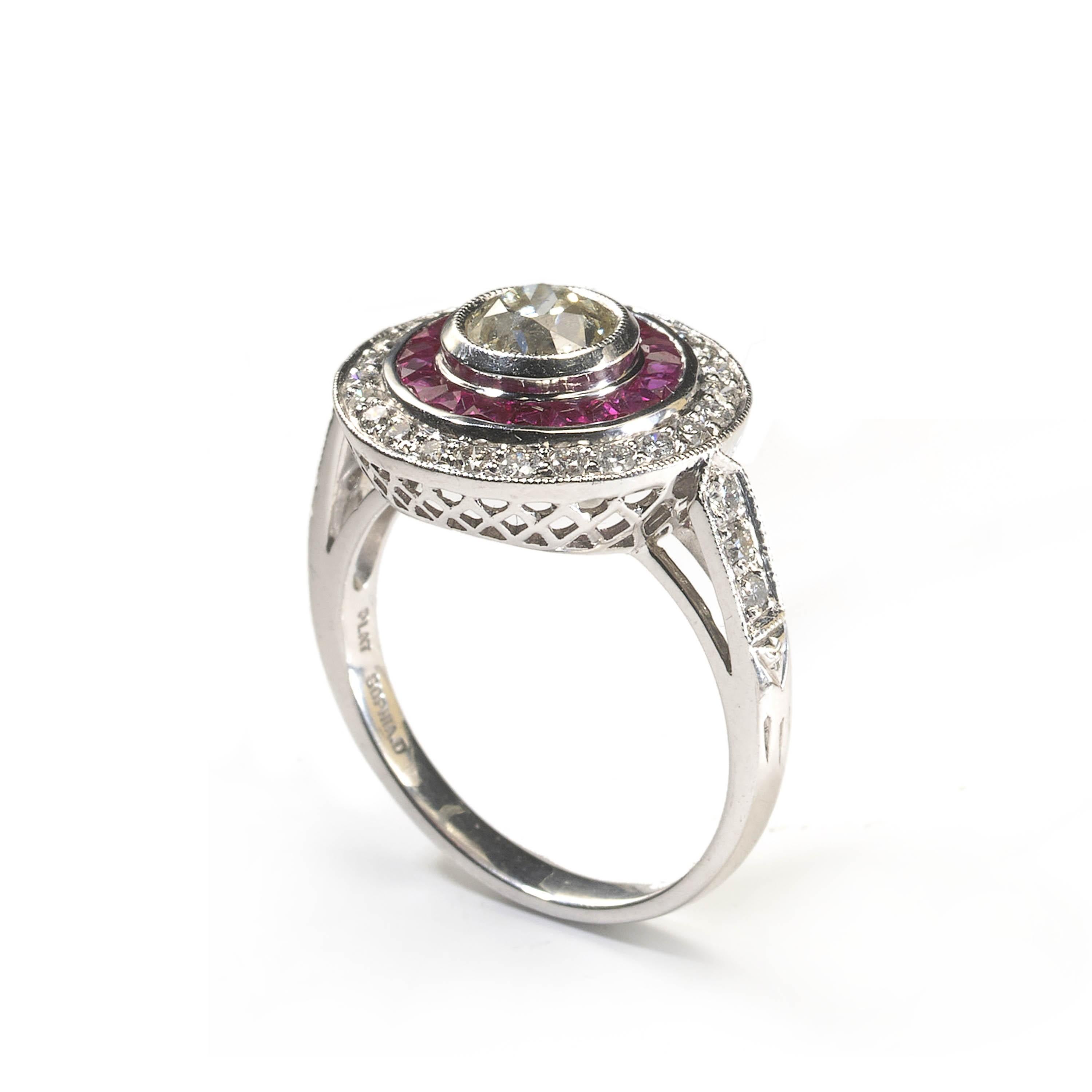 An Art Deco style diamond and ruby ring, set with a 0.93ct round European old-cut diamond, in our opinion the colour is K to L, our opinion of the clarity is VS, in a millegrain edged rub over setting, surrounded by nineteen, French-cut rubies, with