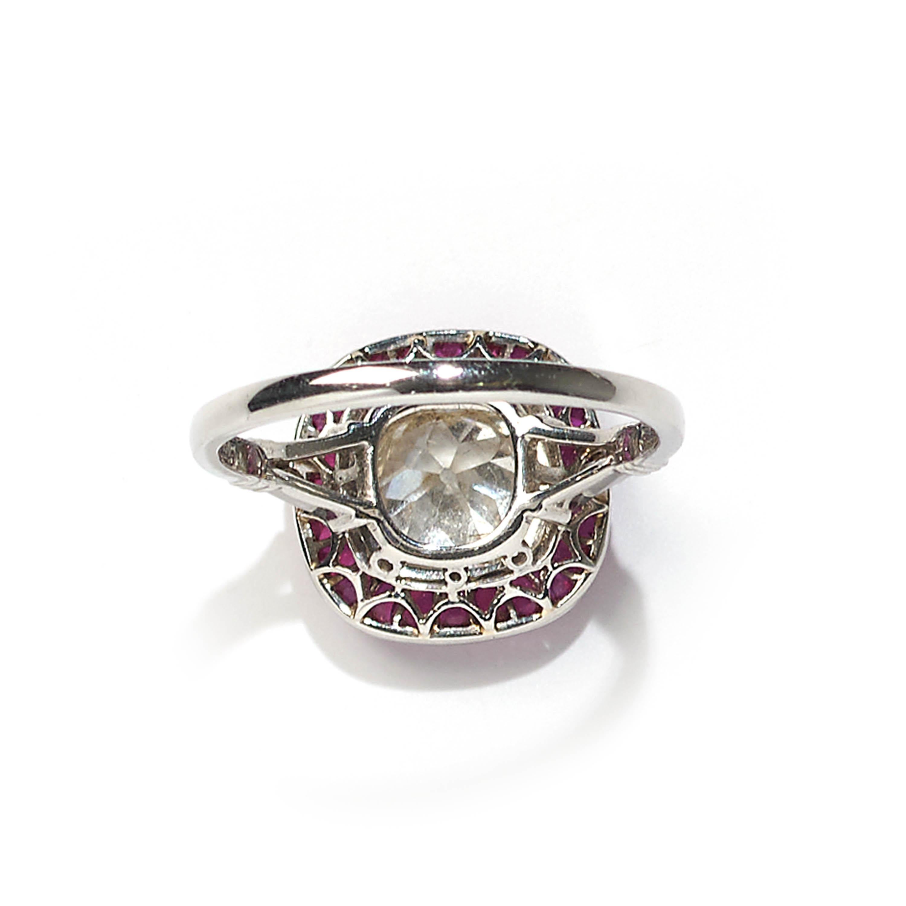 A modern cushion-shaped cluster ring, the central cushion-cut diamond weighing 1.32 carats, surrounded by a border of rubies weighing a total of 2.30 carats, all mounted in platinum.