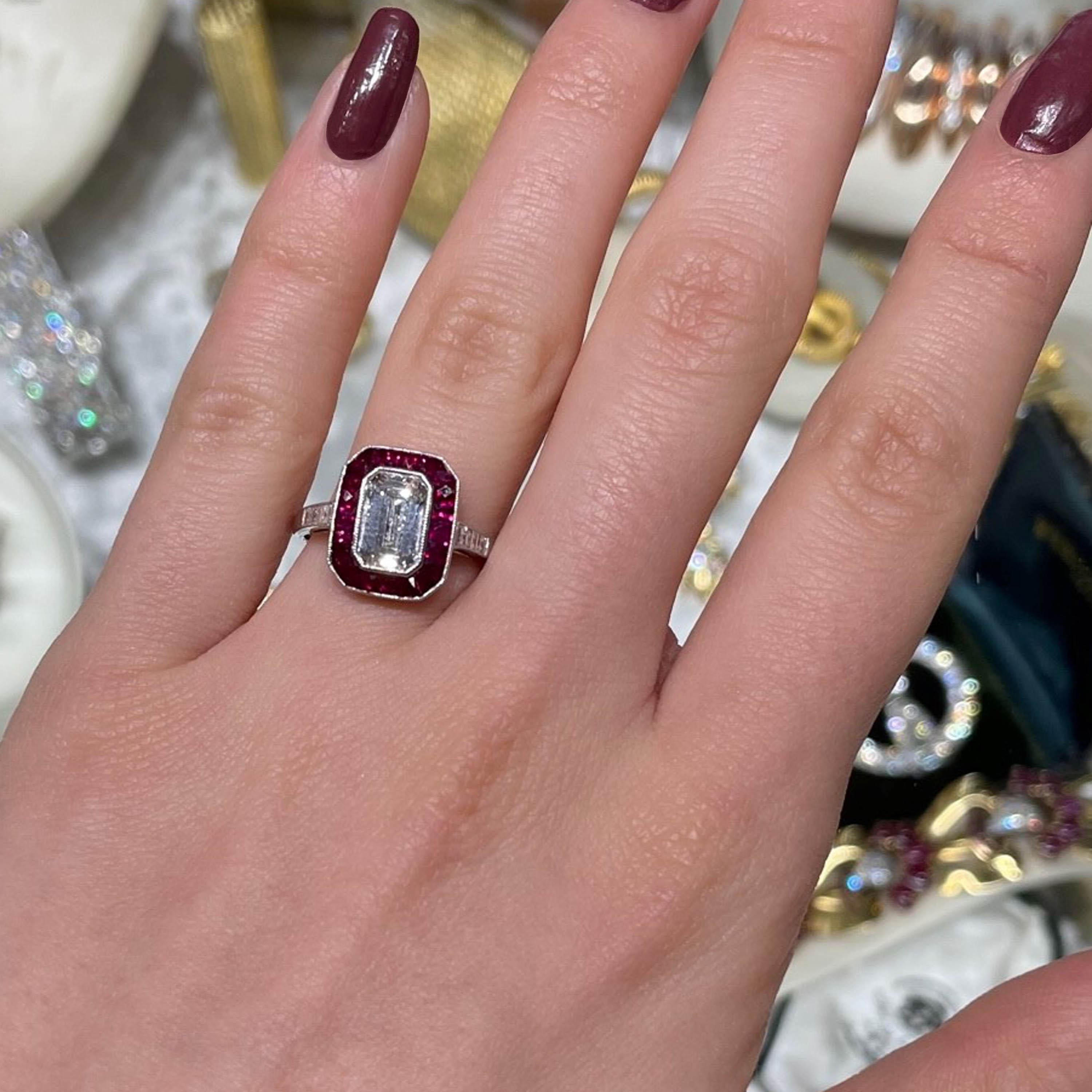A modern octagonal shaped cluster ring, set with a central emerald-cut diamond, weighing 1.52 carats, in a grained rub-over setting, surrounded by rubies weighing a total of 1.52 carats, with a total of 0.18 carats of diamonds set to the shoulders,