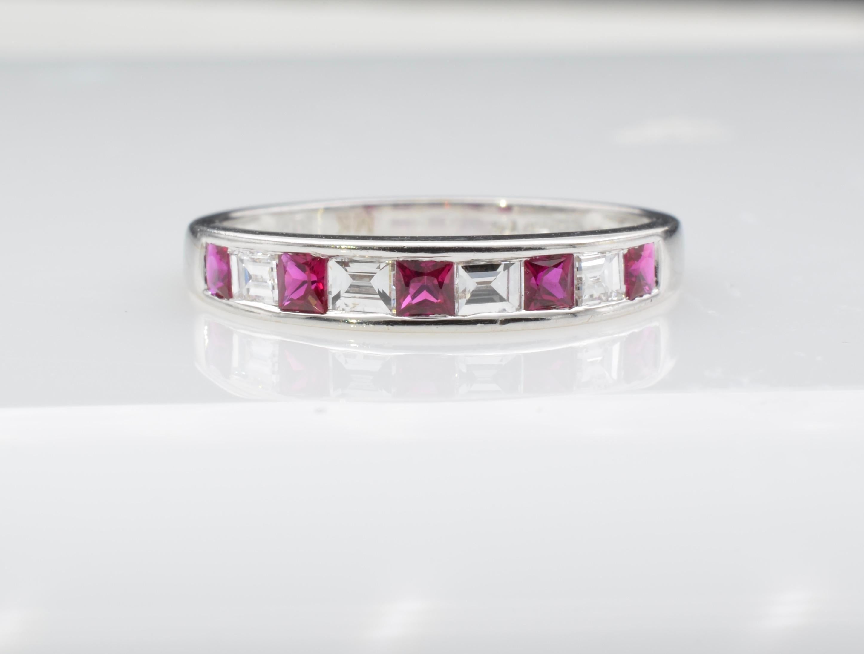 This elegant ruby and diamond wedding band has a modern look with the diamond baguettes (aprox. 0.30 ct) aligned with the princess cut rubies (aprox. 0.35 ct) set in unison in 18k white gold. The ring is stunning alone or to stack with your