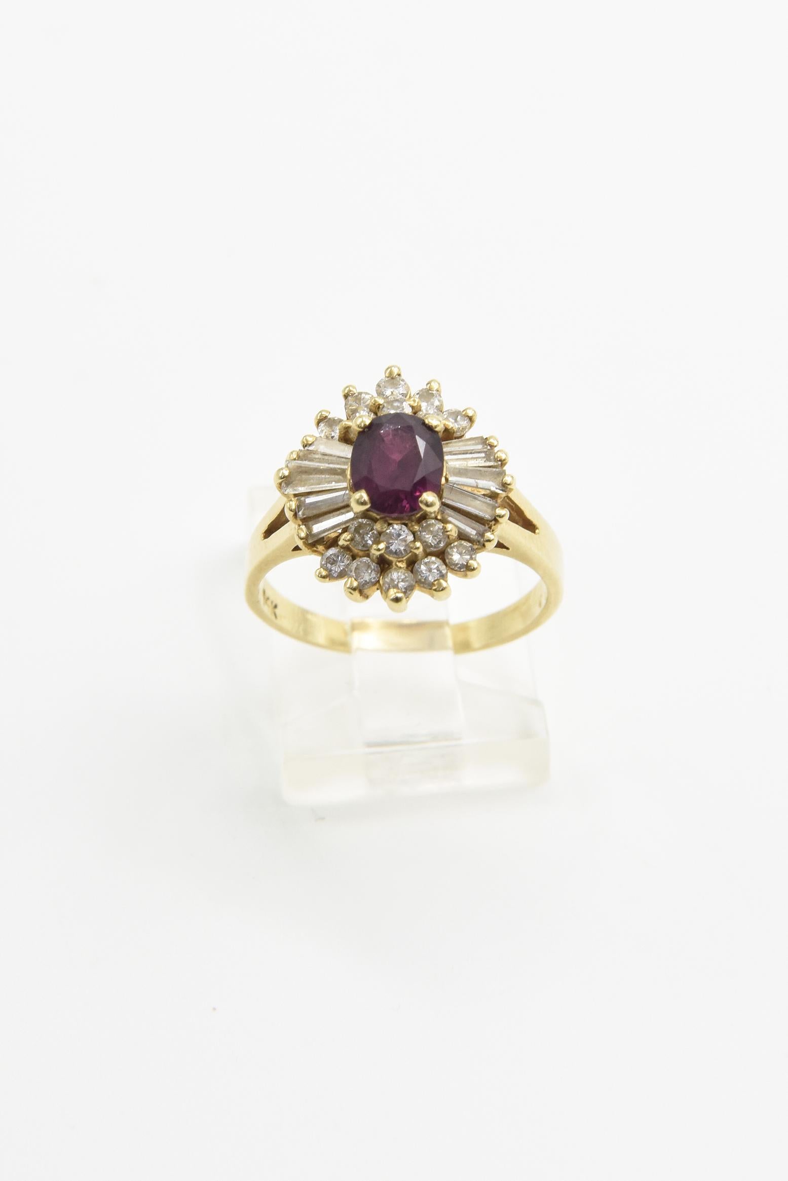 Élégante bague en or jaune 14k contenant un rubis ovale serti au centre d'une monture en diamant ballerine avec des diamants ronds et baguettes.  Il y a environ 1 carat de diamants.  Le rubis mesure environ 6,38 mm de haut et 5,34 mm de large. Le