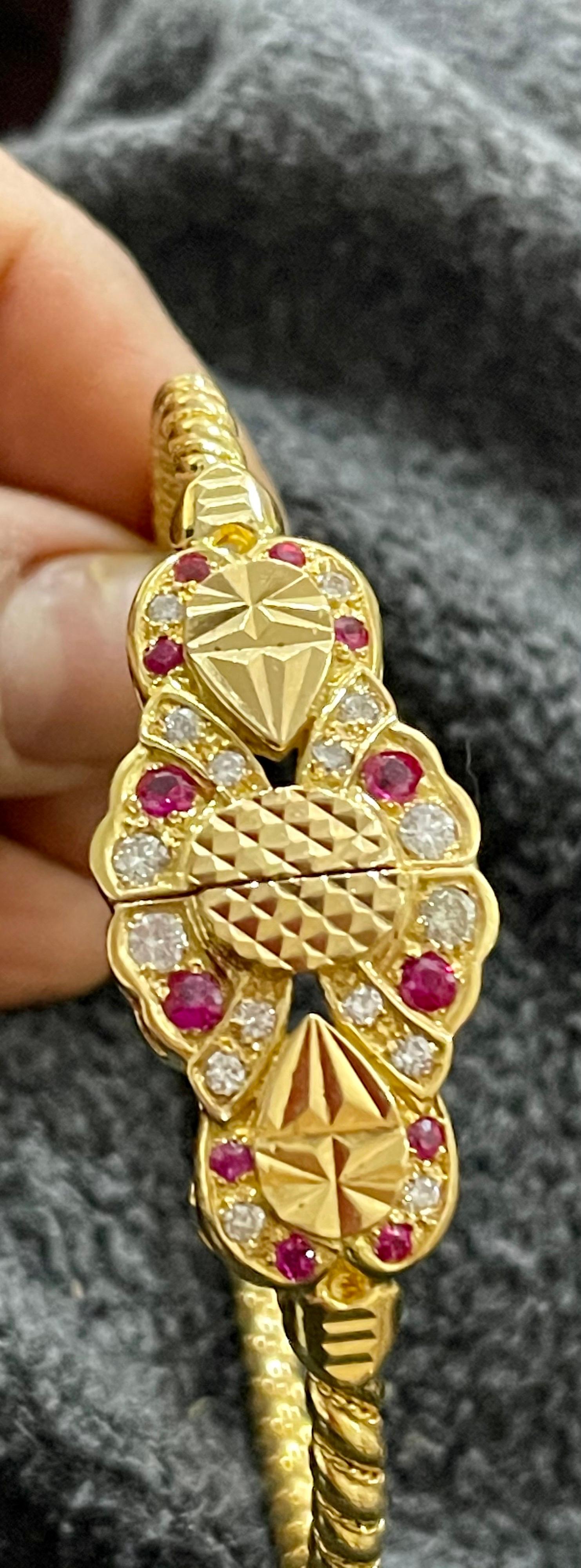 Ruby & Diamond  Bangle /Bracelet in 21 Karat Yellow Gold 34.6 Grams
It features a bangle style  Bracelet crafted from an 21 Karat  Yellow gold and embedded with   12 round Rubies weighting approximately 0.7 Carat
 There are  16 Round diamonds and it
