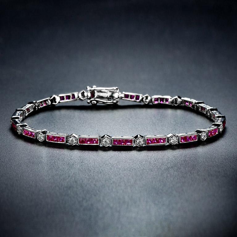 Luxuriant and colorful, this bracelet features alternating triple baguette ruby and round brilliant-cut diamonds. 18K white gold lends security to the classic Art-Deco style and a box clasp with hidden safety keeps this stunner