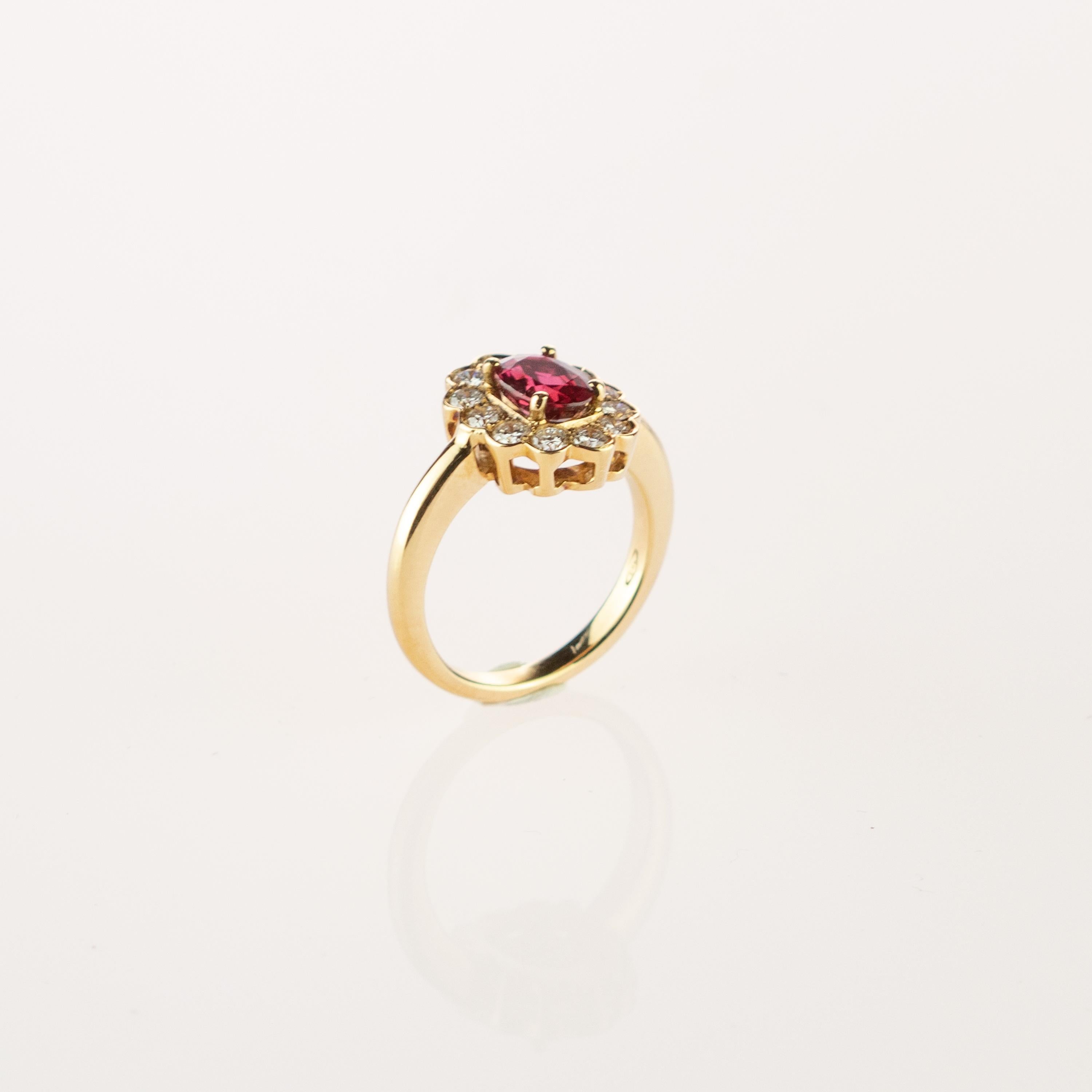 Iconic and modern gold ring with an oval ruby (1.30 carat) with 12 round brilliant diamonds surrounding and forming a flower shape. The delicate 18 karat gold threads complement the fine stones creating a subtle and delicate woven. A magnificent