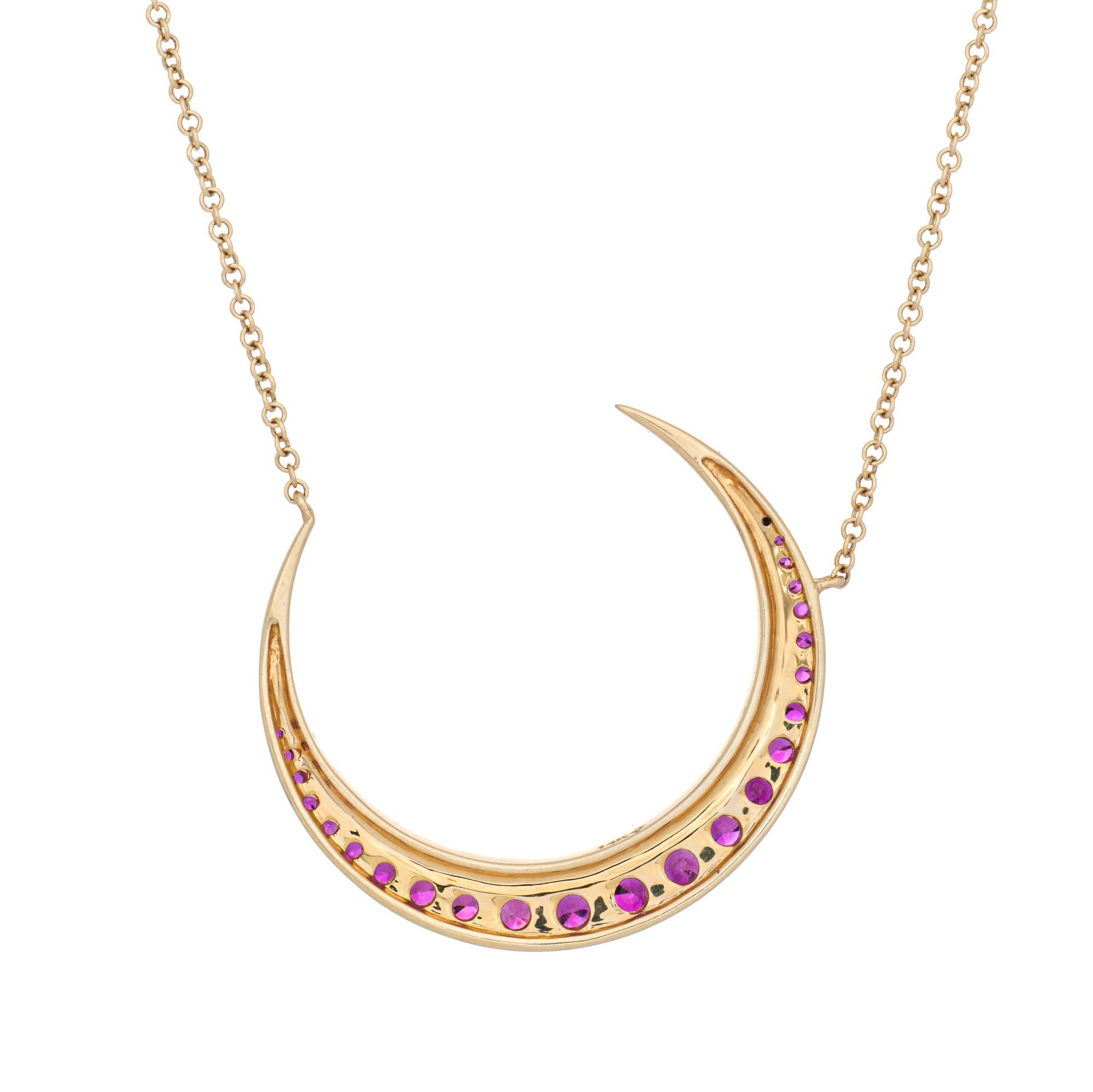 Stylish ruby & diamond crescent moon necklace crafted in 14 karat yellow gold.
Diamonds total an estimated 0.14 carats (estimated at I-J color and SI1-I1 clarity). Rubies total an estimated 0.50 carats. 

Set into a classic crescent moon motif, the