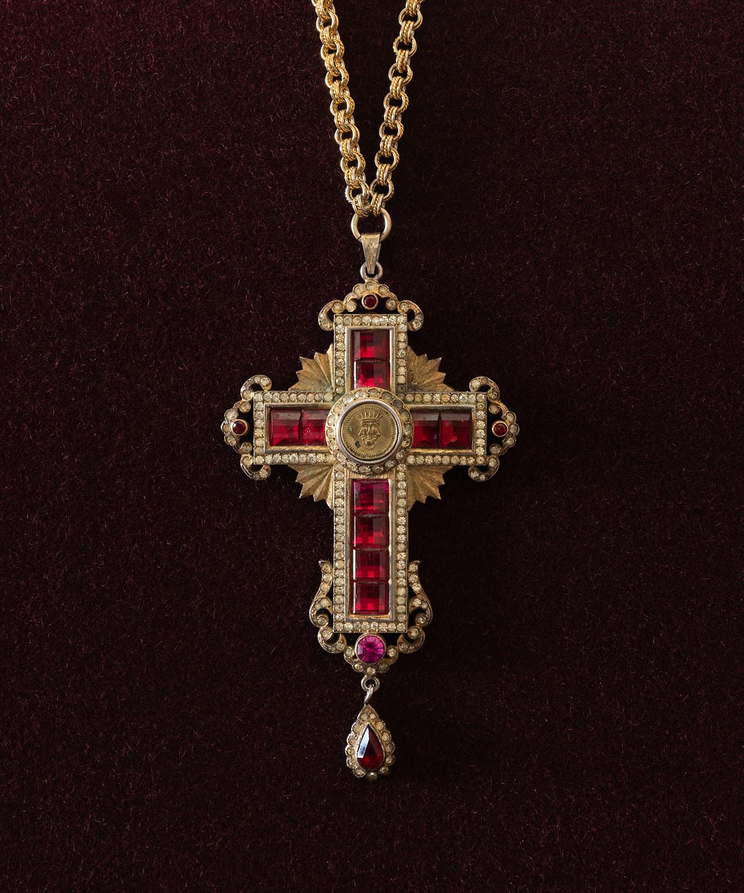 Ruby and diamond cross medallion, Italy, circa 1940.

Comes fitted within original felt-lined, leather-bound box; gilded metal with costume ruby and diamond inlay, with embossed trinity symbol at the center, and hanging from a weighty golden