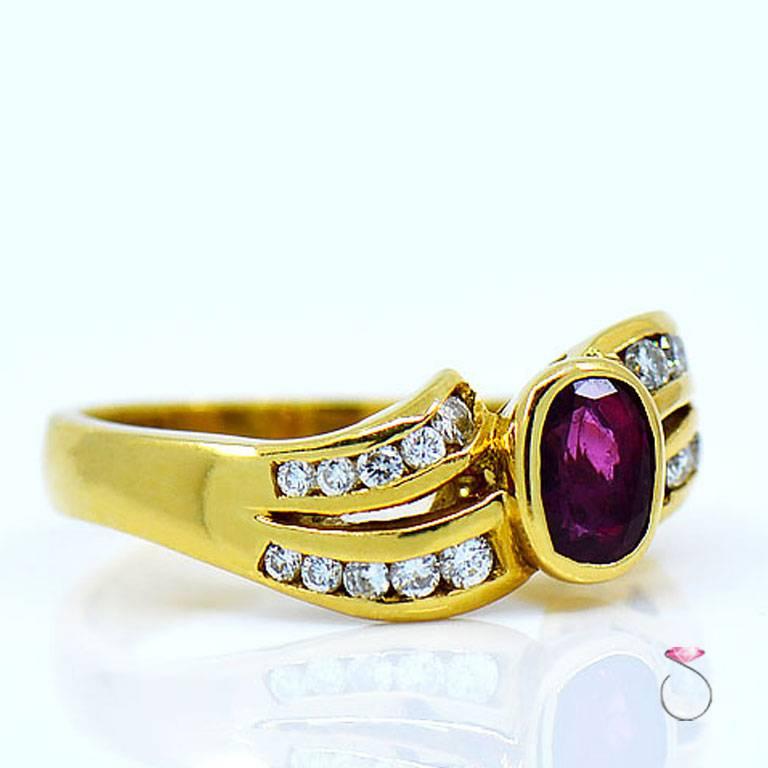 Ruby & diamond ring by Assor Gioielli. Beautiful oval shape red ruby set in a well crafted 18k yellow gold ring & flanked by two rows of round brilliant cut diamonds on both sides in a wave design. The approximately 0.75 carat Ruby measures