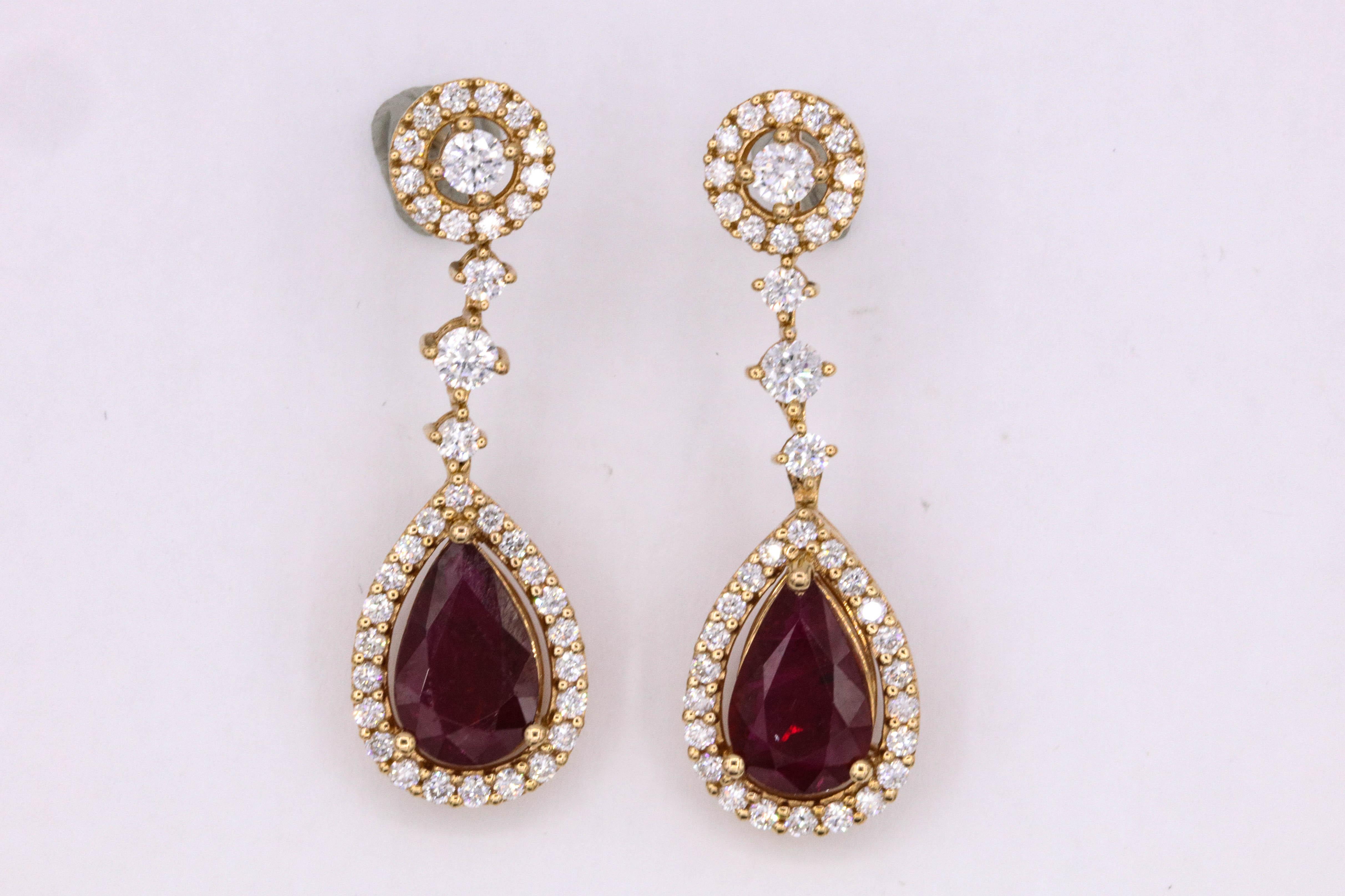 18k Rose gold drop earrings featuring two pear shape red rubies, 3.38 carats surrounded by round brilliants weighing 1.31 carats.
Color G-H
Clarity SI