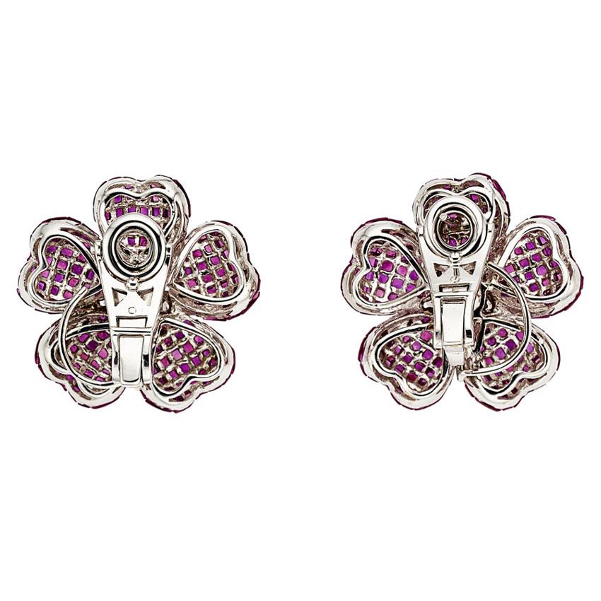 For the love of flowers! A stunning floret pair of earrings featuring approximately 11.00 carats of fine caliber cut rubies with a diamond cluster center weighing 1.25 carats. This omega back earrings are set in 18K white gold. These pair of