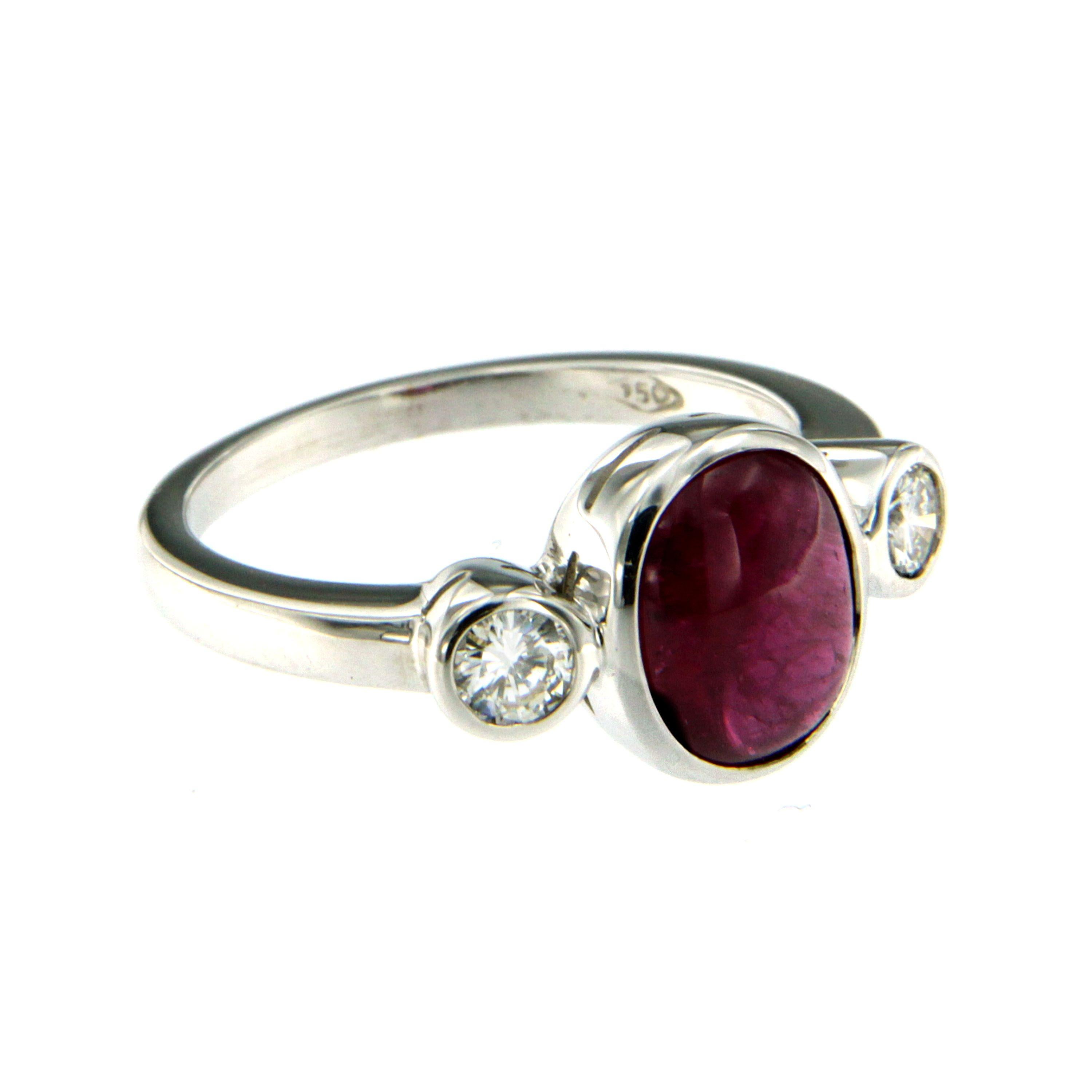 18k white Gold three stone ring containing one oval cut cabochon Ruby weighing 2.00 carat flanked by two round brilliant cut diamonds weighing 0.40 total cts G color vvs clarity. Circa 1960

Ring Size: US 6.5 - IT 13 - FR 53 - UK N 
This ring may be