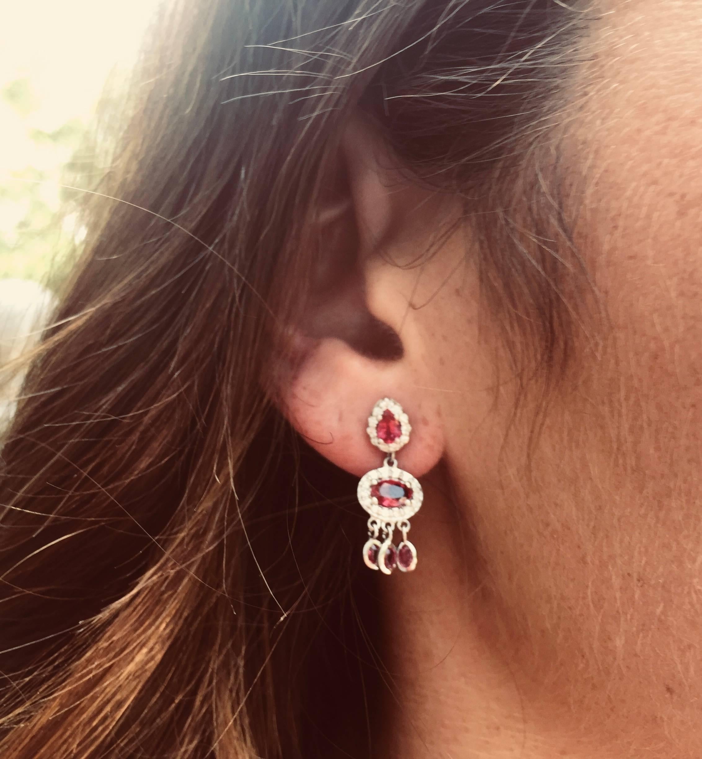 Featuring 18k white gold drop earrings 
Halo pear shape and oval shape ruby weighing 3.00 carat 
Cluster diamond weighing 1.05 carat 
New Earrings
Handmade in USA
18k gold earrings are hanging off a post with push-backs
Ruby has a rainbow of color