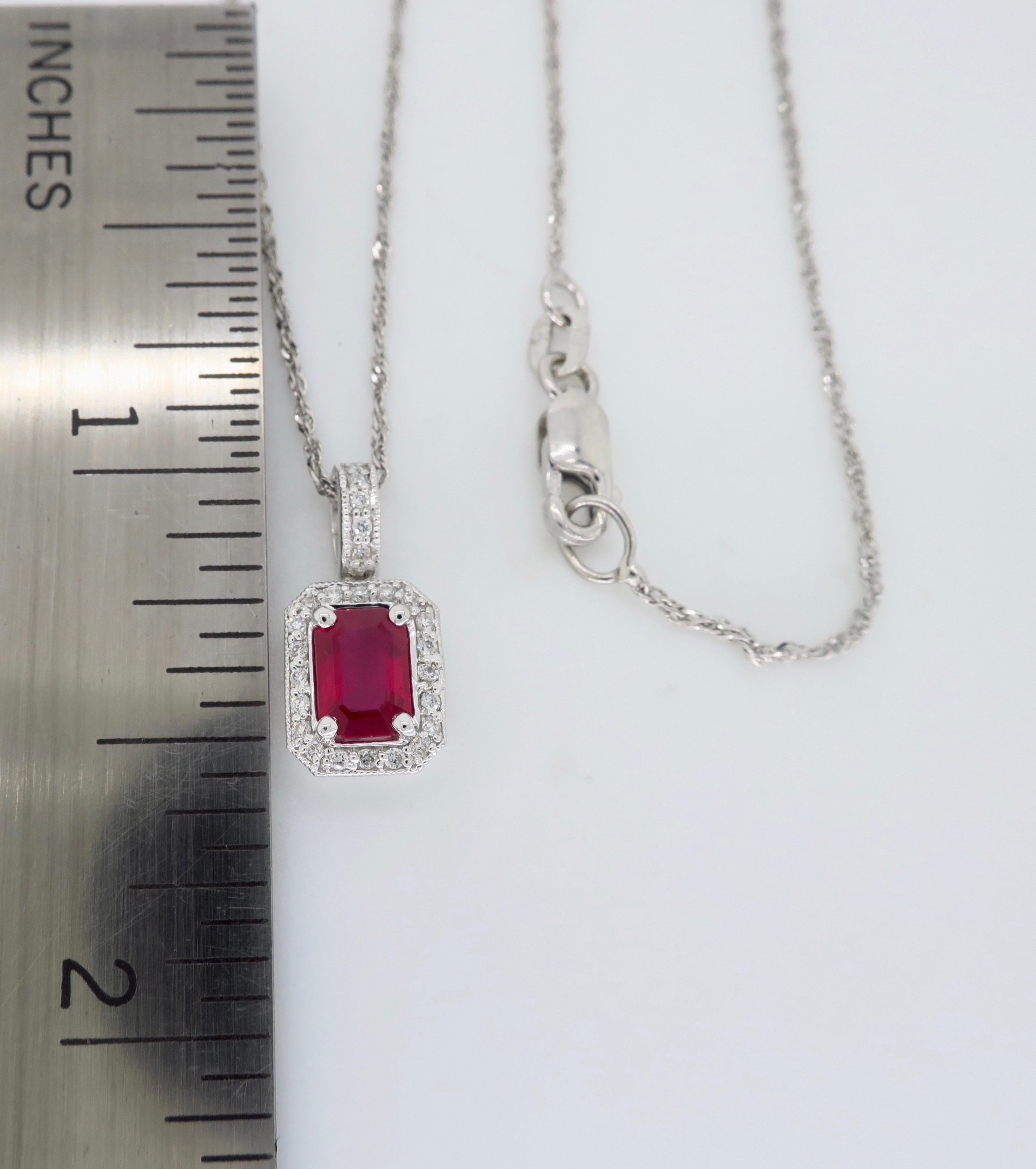 Ruby and diamond halo style pendant necklace crafted in 14k white gold.

Gemstone: Approximately 4x6mm Ruby
Diamond Carat Weight: .13CTW
Diamond Cut: Round Brilliant Diamond
Color: Average G-I
Clarity: Average SI-I
Metal: 14K White Gold 
Chain
